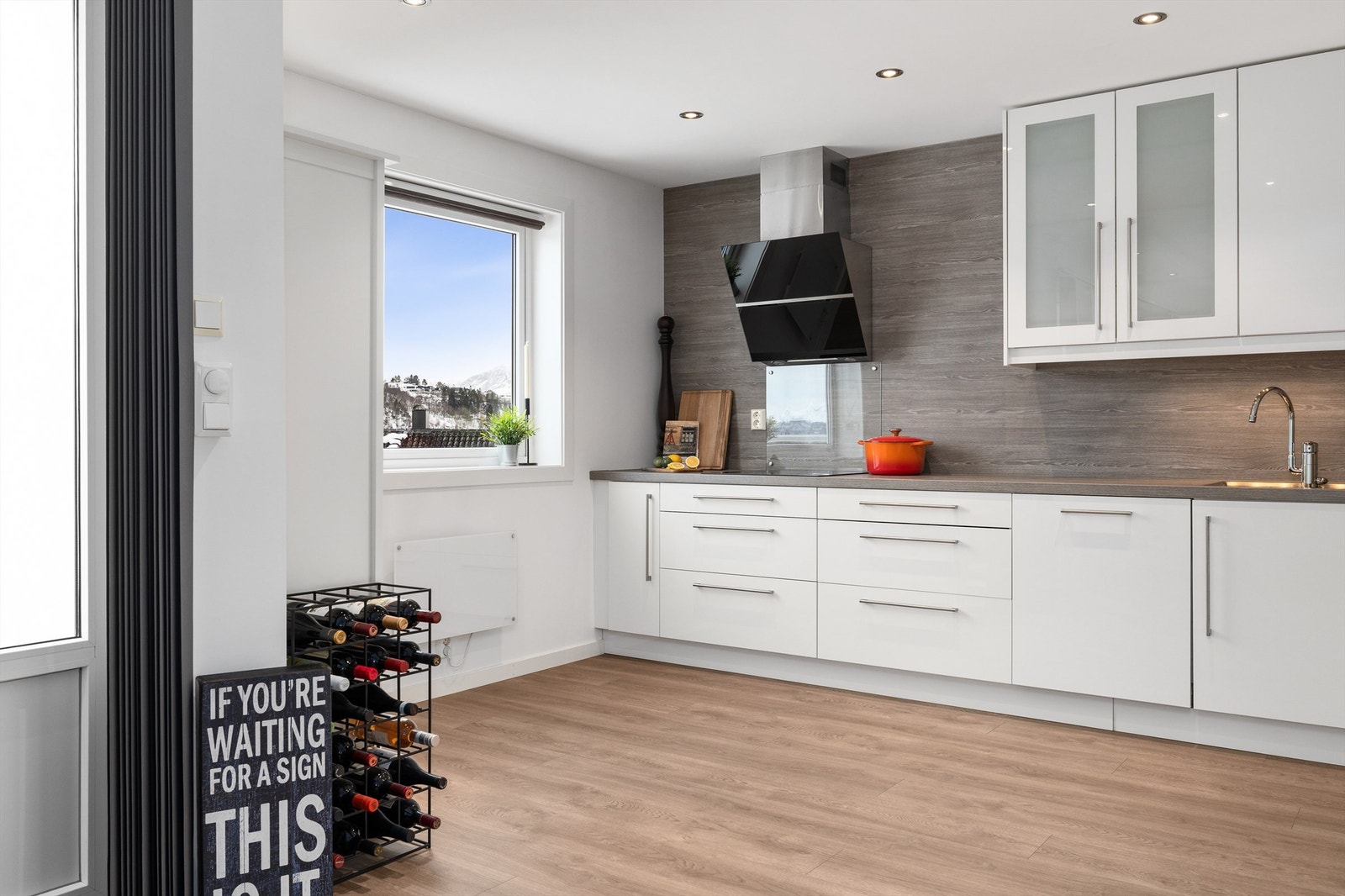 Pent og romslig kjøkken med masse skapplass, decorplate på vegg og laminat benkeplate Galleribilde