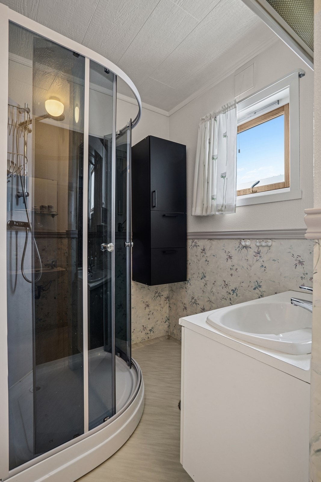 Badet i 1.etg. er utstyrt med dusjkabinett, skap og servant Galleribilde