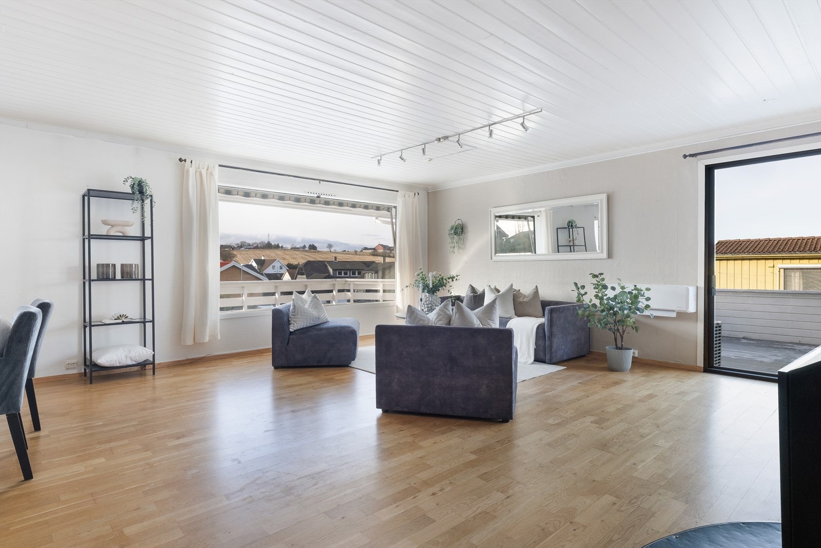 Romslig stue med store vindusflater Galleribilde