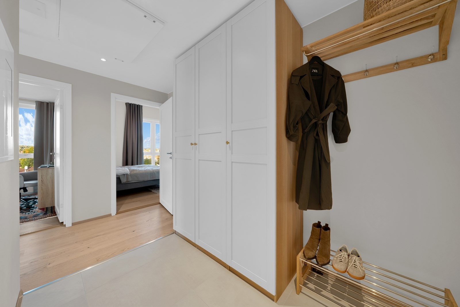 Flislagt entrè med god plass til å henge fra seg yttertøyet og legge fra seg skoene. Galleribilde