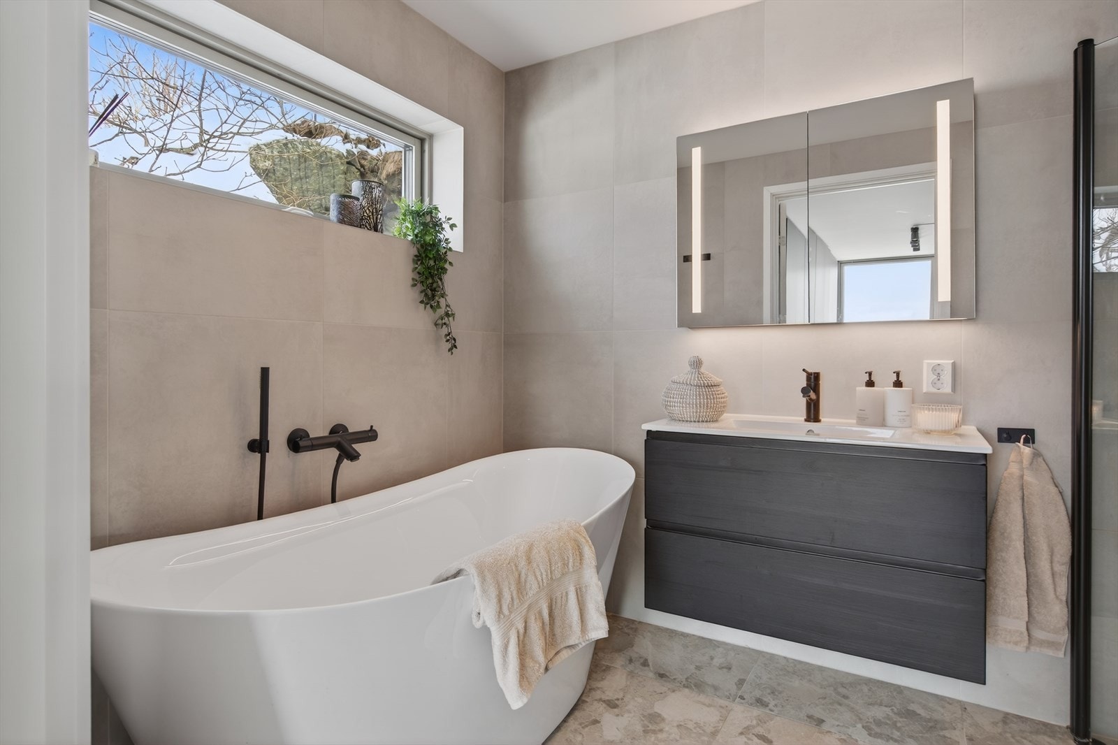 Badet tilknyttet foreldresuiten har store, delikate fliser på vegger og gulv. Galleribilde