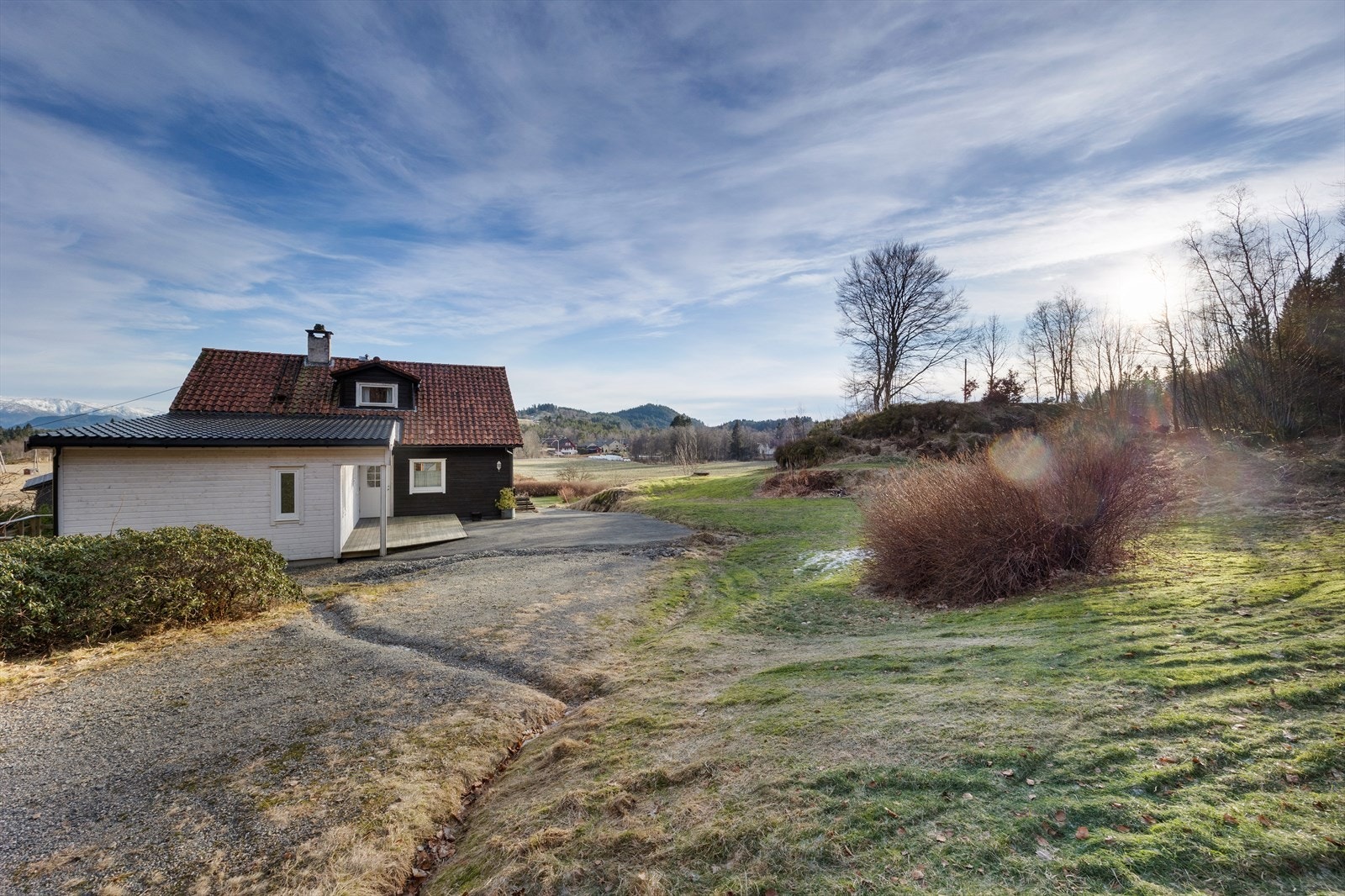Tomten er romslig og er pent opparbeidet med plen, beplantning, singel og asfalt. Galleribilde