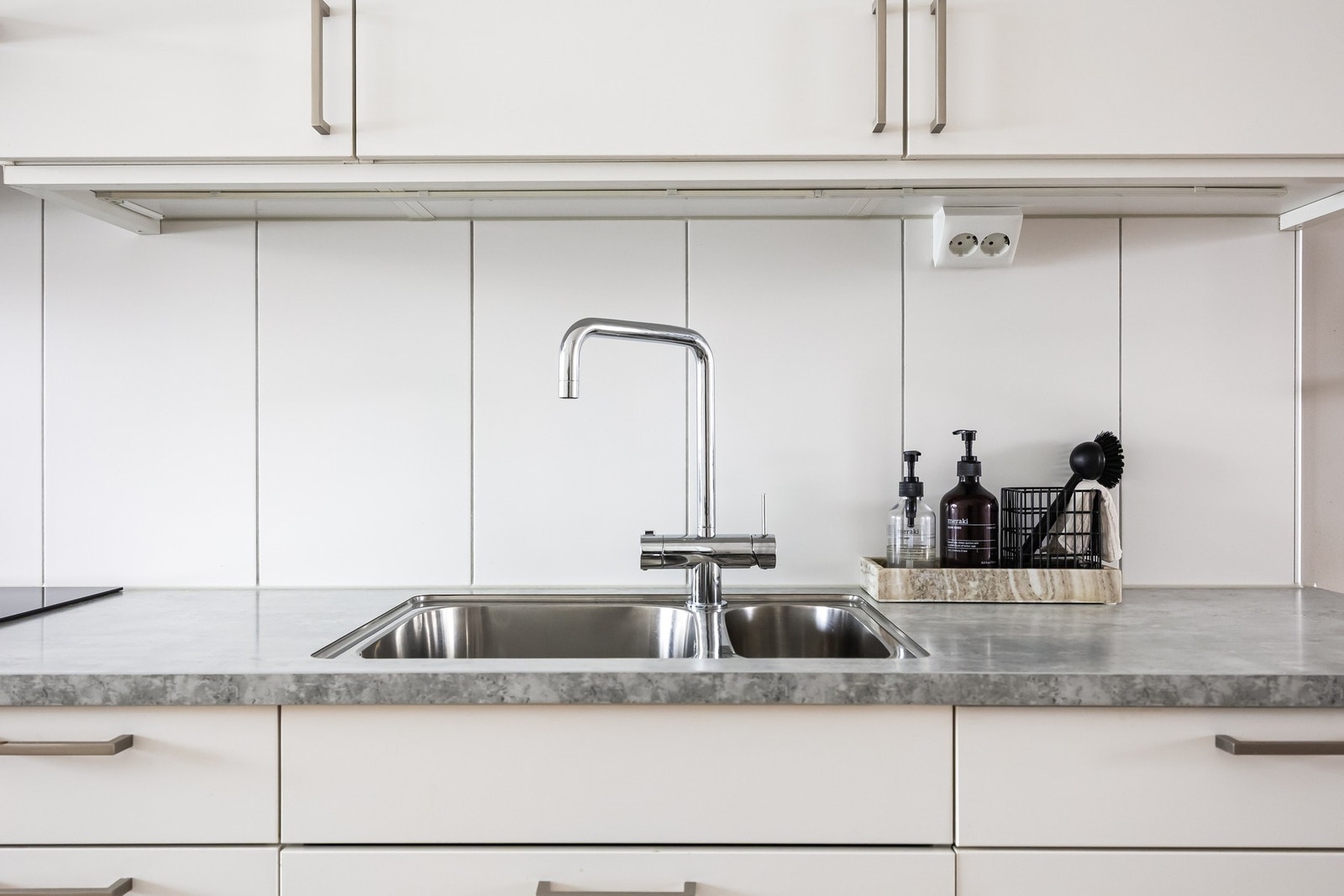 Det er belysning under overskap, samt fliser på veggen over kjøkkenbenken som både er praktisk og gir et stilfullt preg. Galleribilde