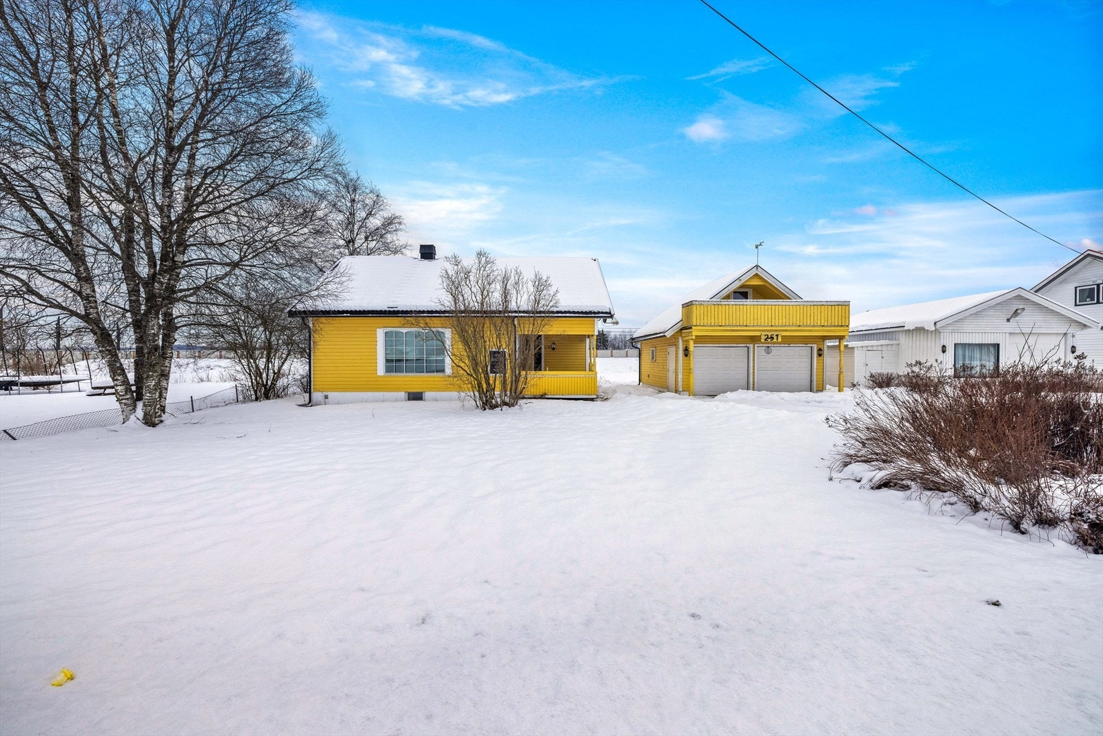 Fin hage med plen og prydbusker. Asfaltert gårdsplass med mulighet for parkering av flere biler. Galleribilde