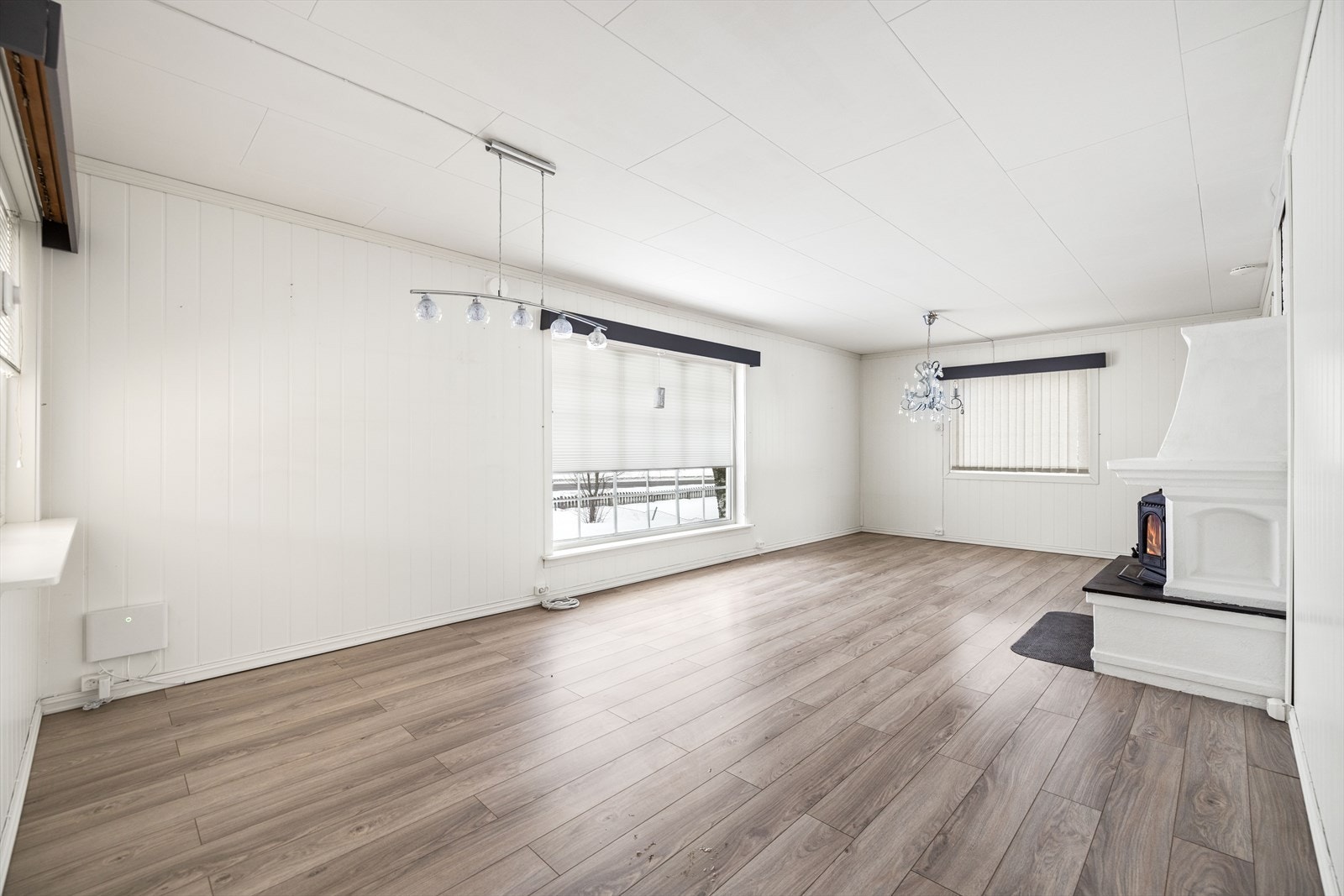 Romslig stue i boligen inngangsplan, med peisovn. Galleribilde