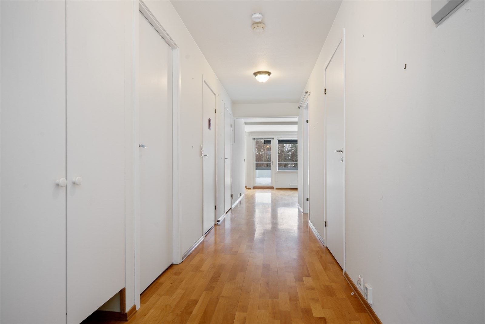 Parkettgulv strekker seg gjennom entréen, og gir en varm og innbydende følelse. Veggene er malt, og det er god plass til oppbevaring. Galleribilde