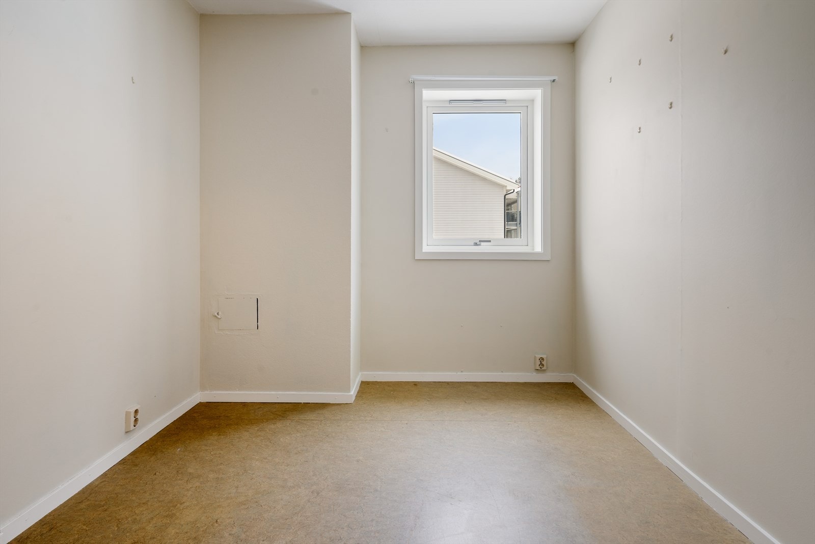 Rommet har malte vegger og belegg på gulvet, med vindu som gir naturlig lys. Galleribilde