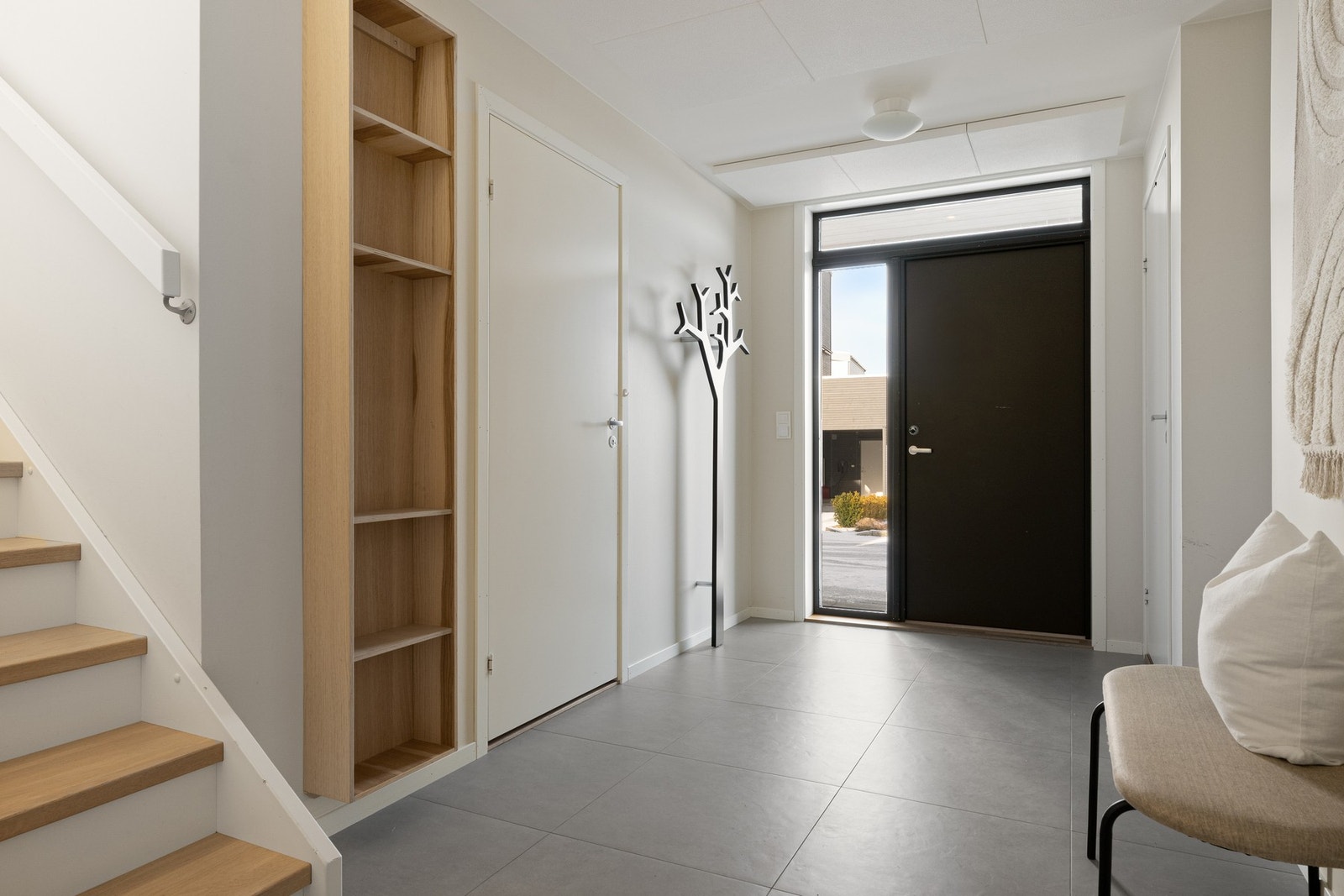 Lys og romslig gang med stilrene 60×60 fliser og behagelig gulvvarme Galleribilde