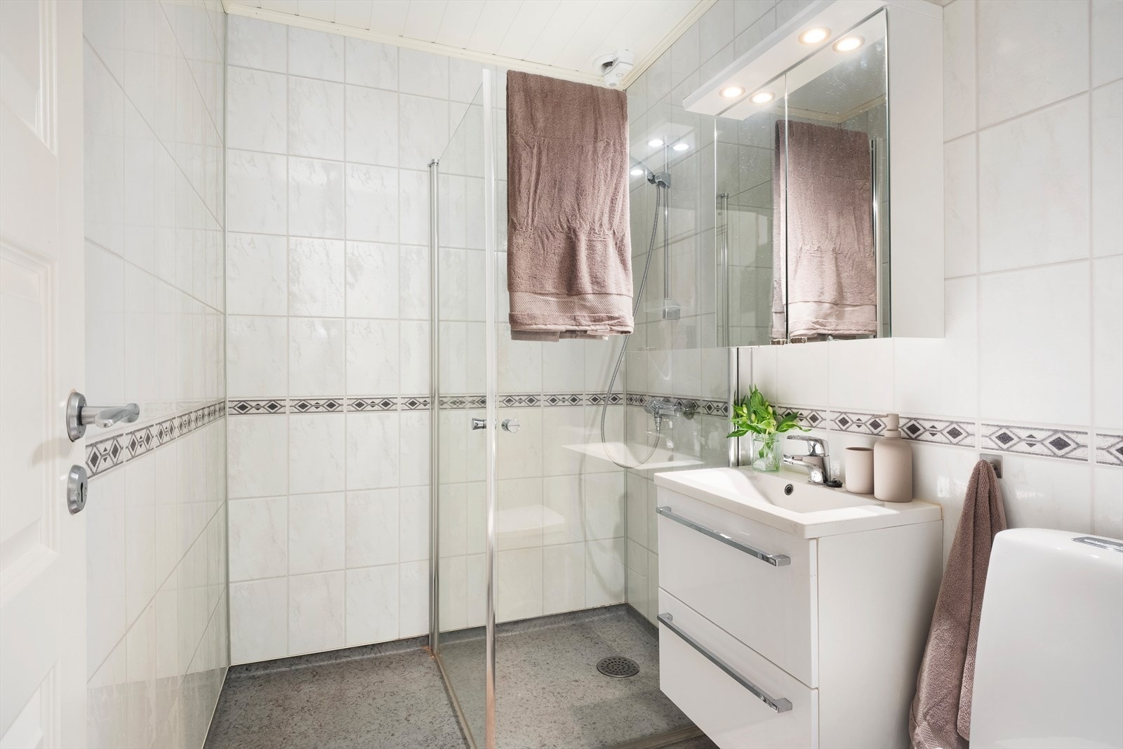 Bad med baderomsplater på veggar og taket har himlingsplater. Golvet har vinylbelegg og elektriske varmekablar. Galleribilde