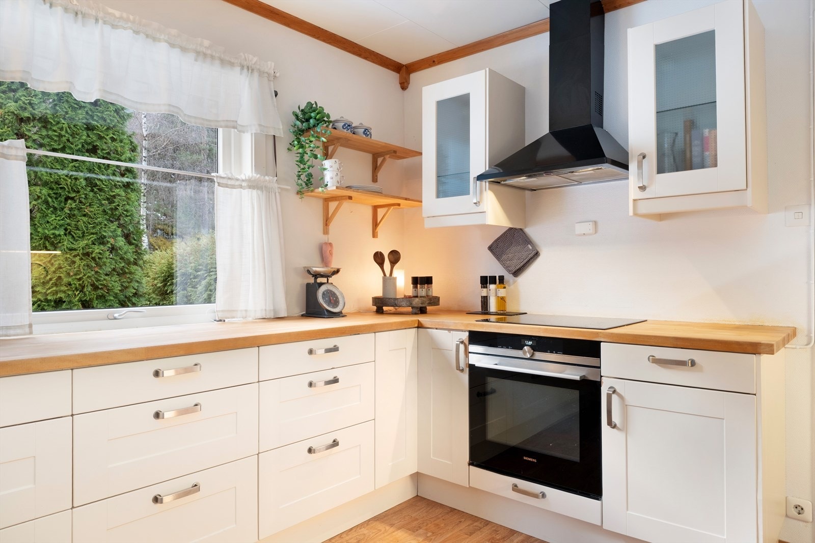 Kjøkkenet har innredning med profilerte frontar og benkeplate av heiltre. Galleribilde