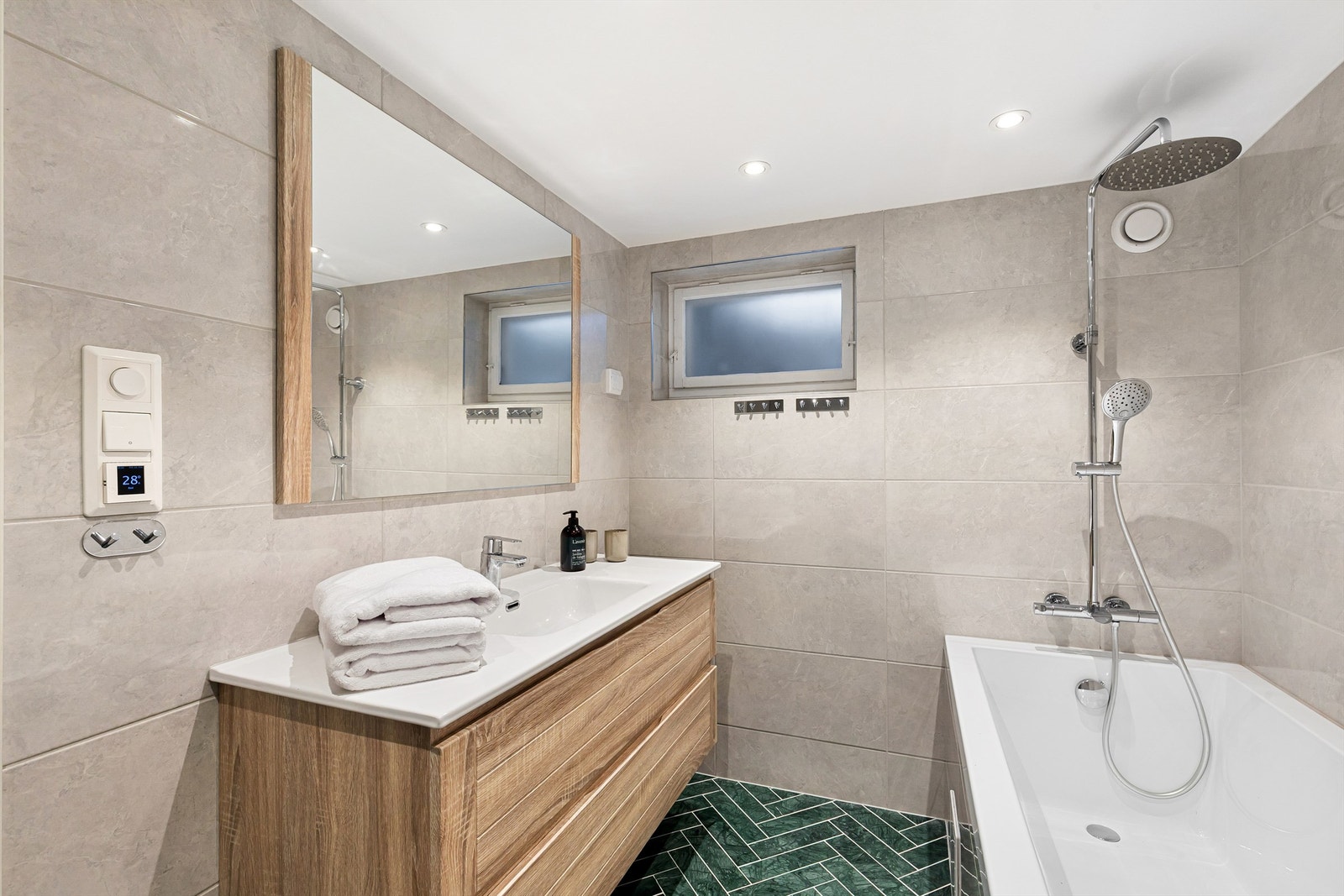 Lekkert bad pusset opp i 2021 med moderne servantmøbel og matchende speil. Badekar med dusjarmatur Galleribilde