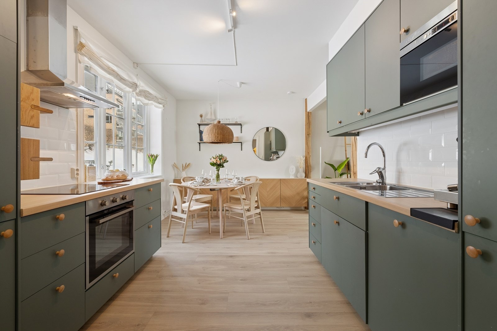 Stilrent kjøkken med heltre benkeplate og glatte, grønne fronter. Galleribilde