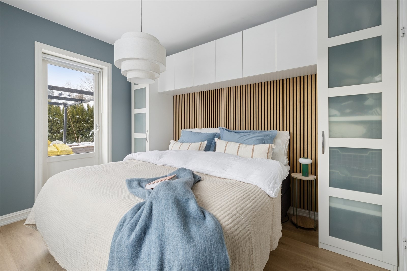 Lunt og rolig soverom med spilekledd vegg og harmoniske fargetoner. Galleribilde