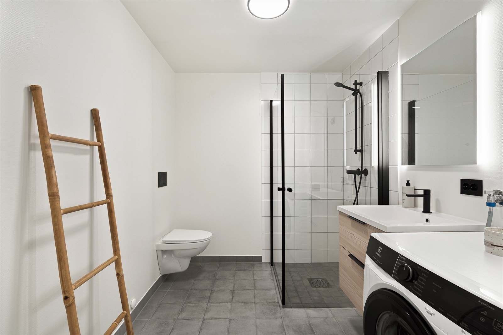 Innredningen består av seksjon med servant, speil med belysning, dusjhjørne, vegghengt toalett og opplegg for vaskemaskin og tørketrommel. Galleribilde