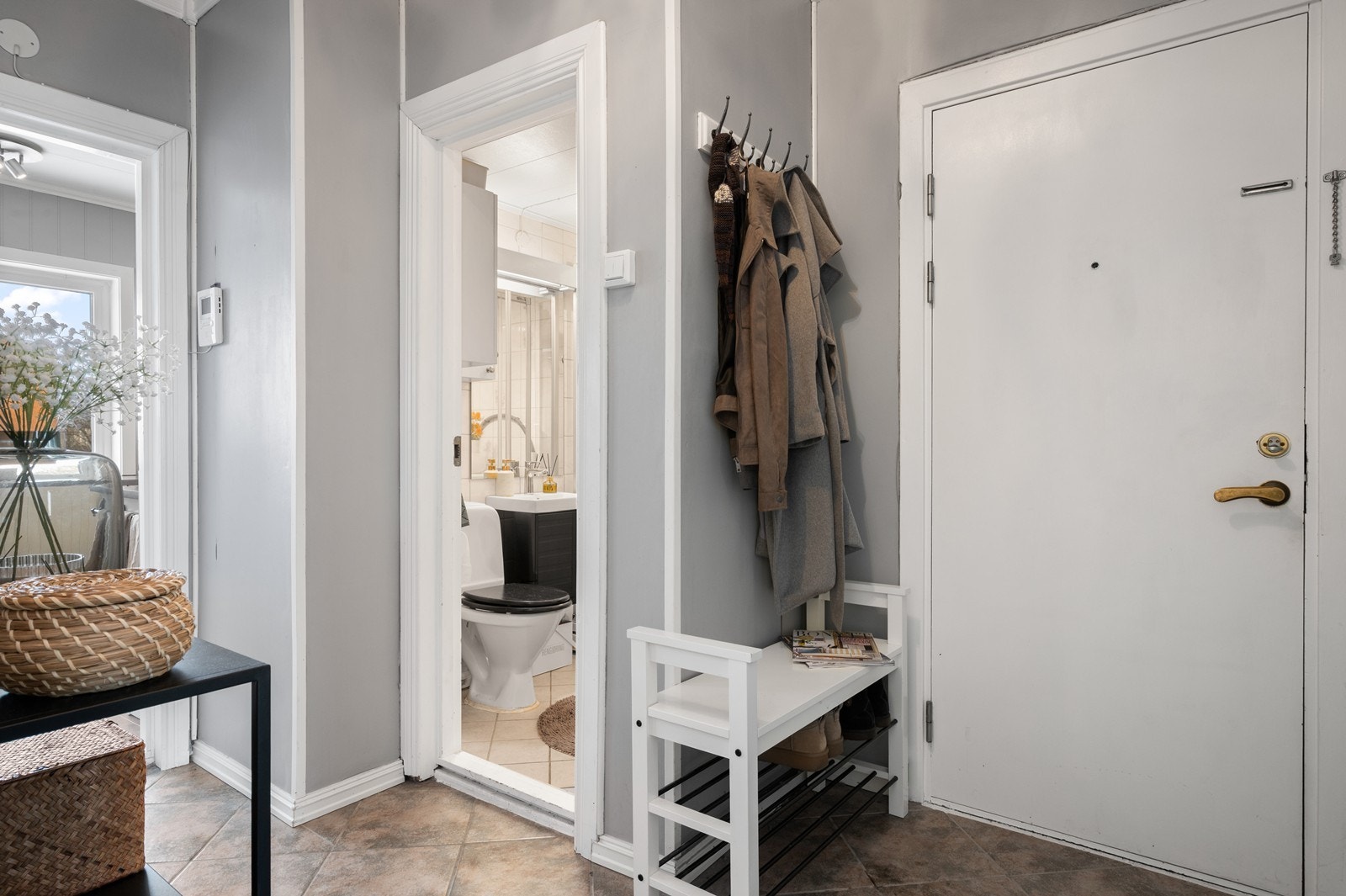 Velkommen inn i en praktisk entré med flislagt gulv og plass til yttertøy. Galleribilde