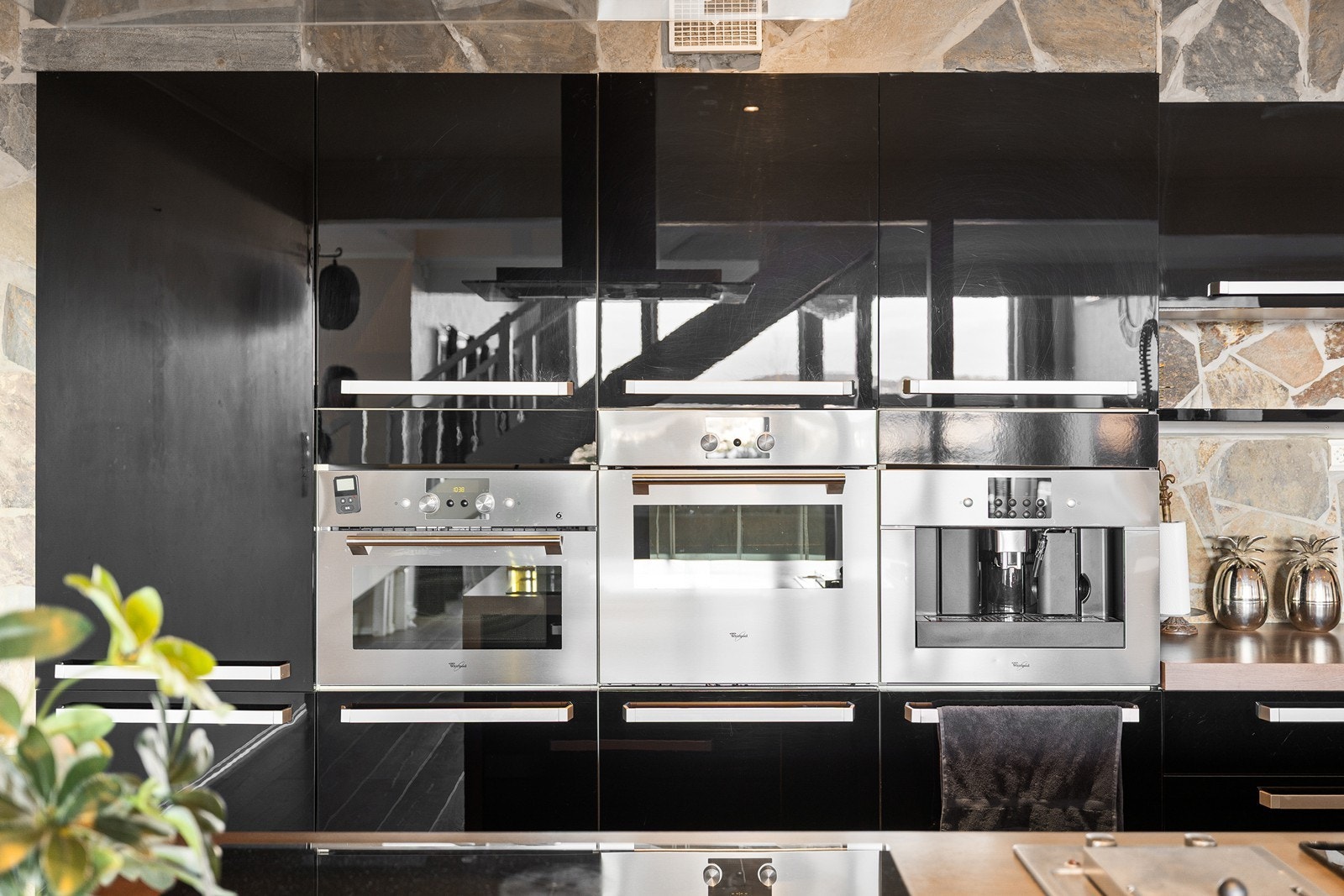 Utstyrsmidlene er i toppklasse med moderne løsninger som ekstra bred induksjonstopp (77 cm), fritthengende ventilator, innebygget grill, frityr, kaffemaskin og side-by-side kjøl- og fryseskap. Galleribilde