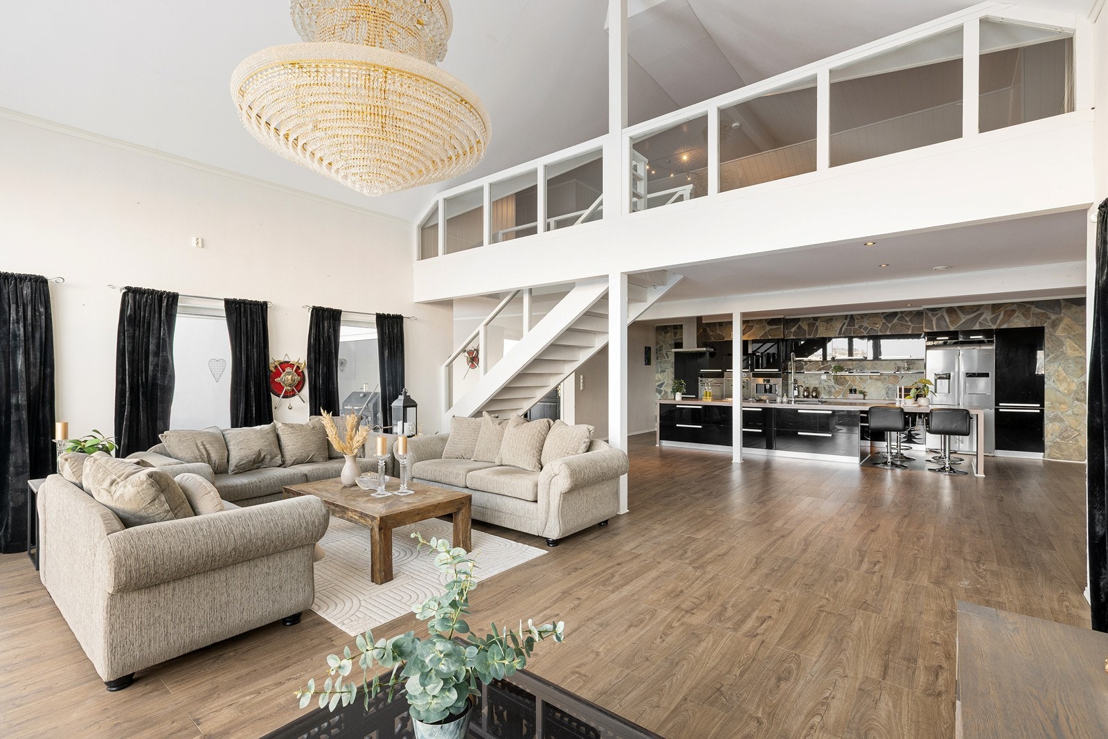 En romslig og sosial sone hvor stue og kjøkken smelter sammen. Legg merke til den storslåtte lysekronen! Galleribilde