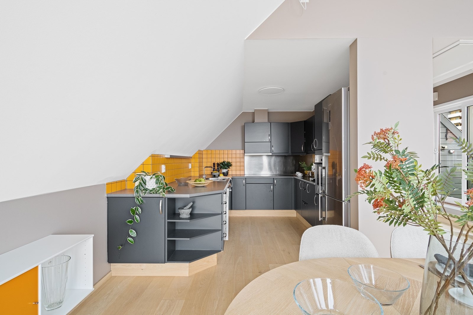 Kjøkkeninnredningen har en tilbaketrukket plassering med delvis åpen løsning mot spisestuen. Galleribilde