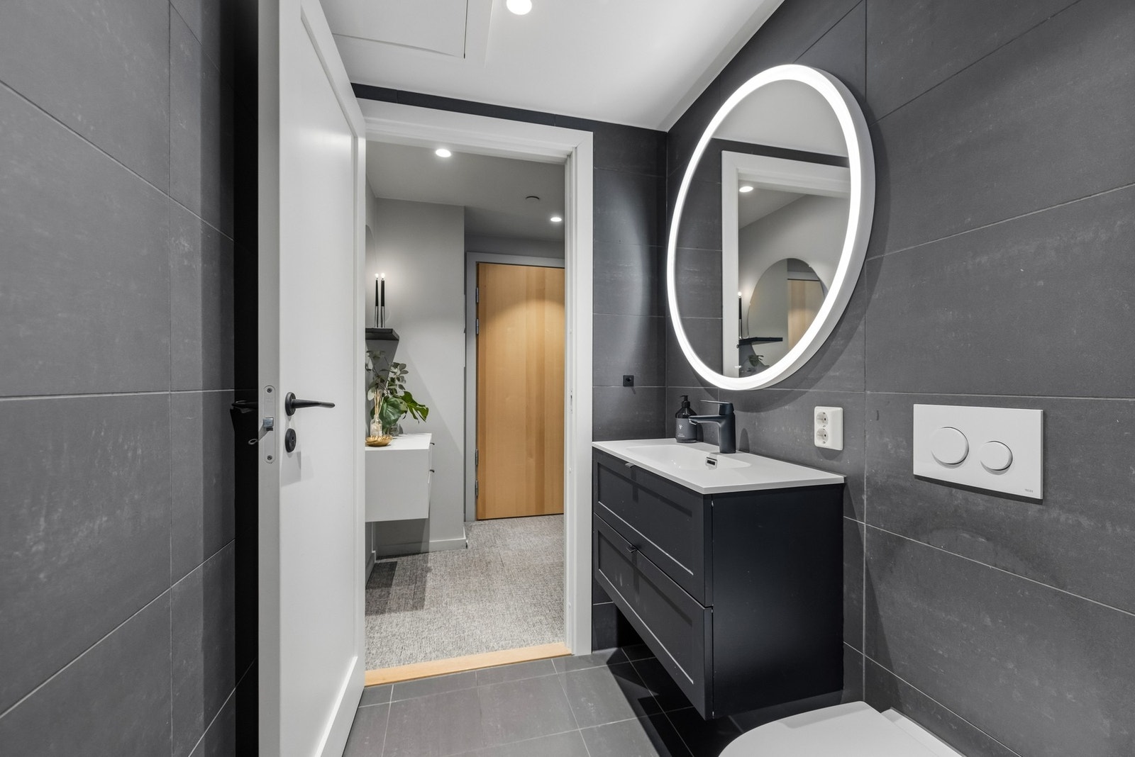 Baderommet er moderne og elegant utført fra byggeåret 2020 med koksgrå fliser og behagelig gulvvarme. Galleribilde