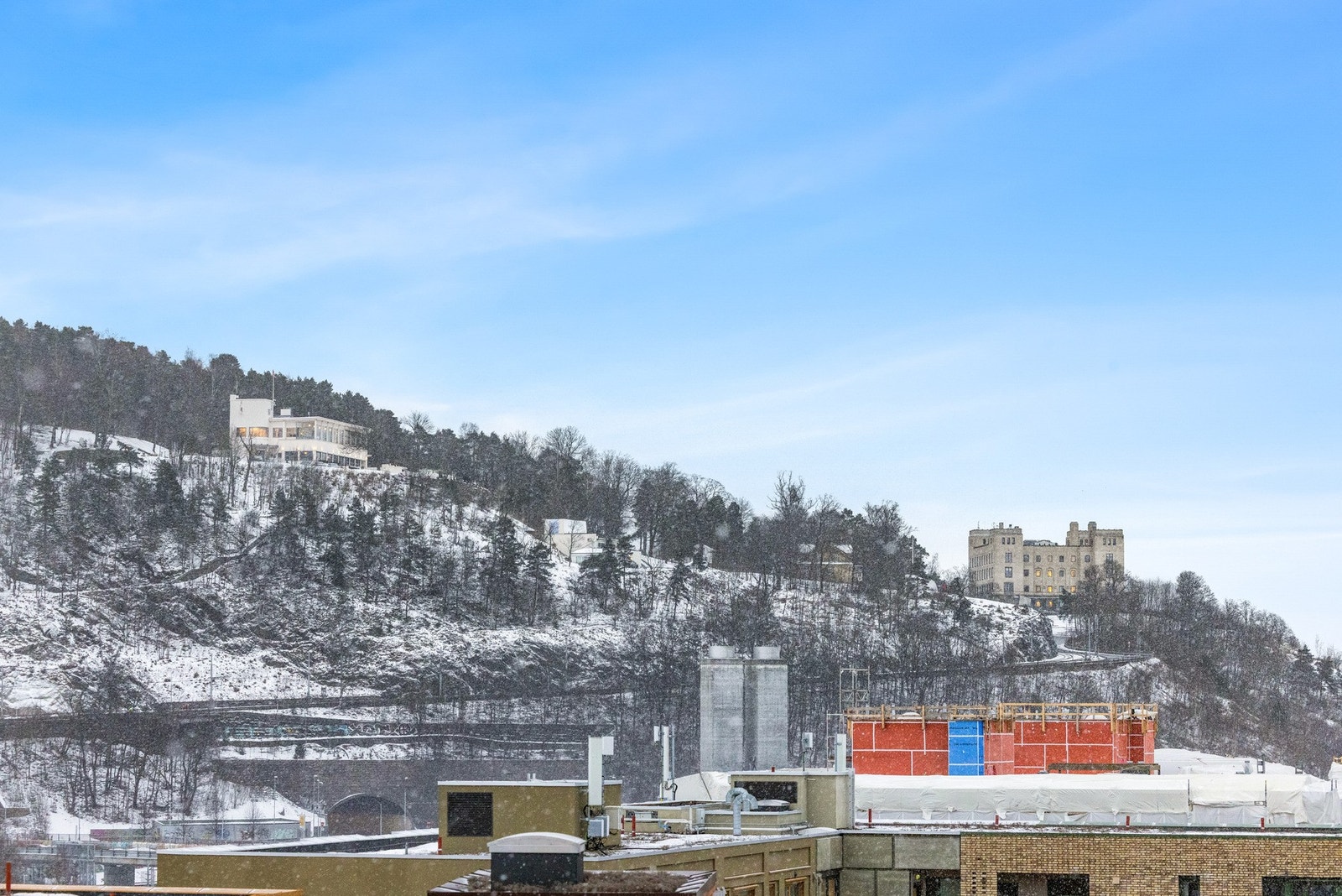 Blikket løftes mot Ekebergåsen og den historiske Ekebergrestauranten, der grønt landskap og klassisk arkitektur danner en vakker kontrast til byens moderne bebyggelse. Galleribilde