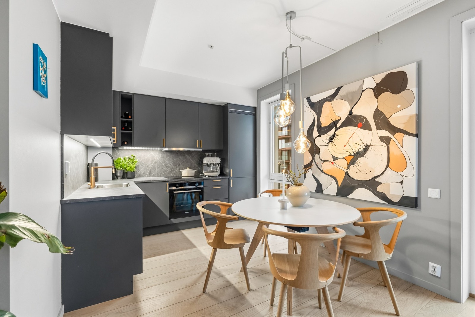 Kjøkkeninnredningen fra 2020 har glatte, koksgrå fronter og takhøye skap som gir rikelig med oppbevaring og et stramt, helhetlig uttrykk. Galleribilde