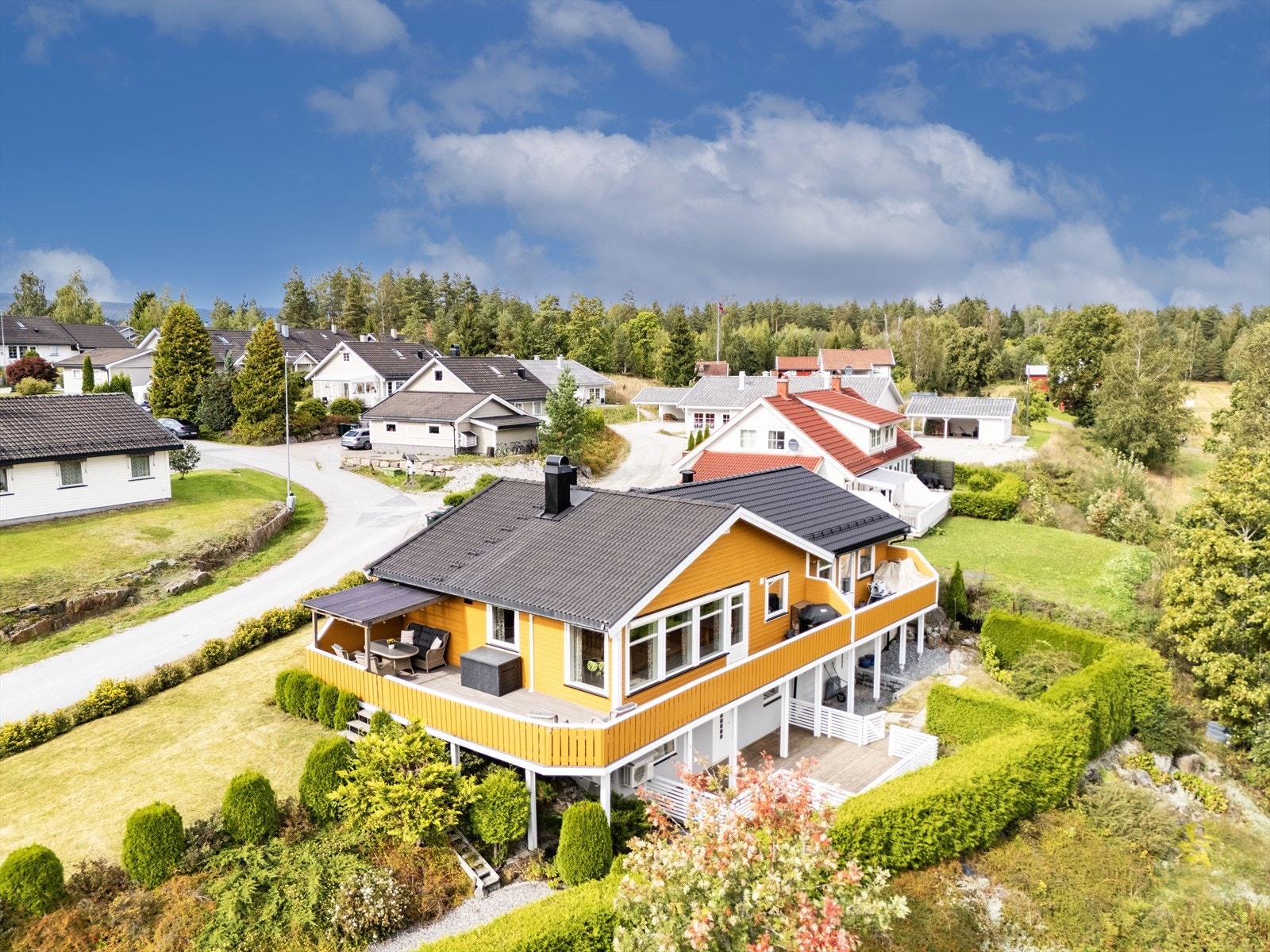 Tomten er av god størrelse og delt omkranset med hekk og diverse beplantning. Galleribilde