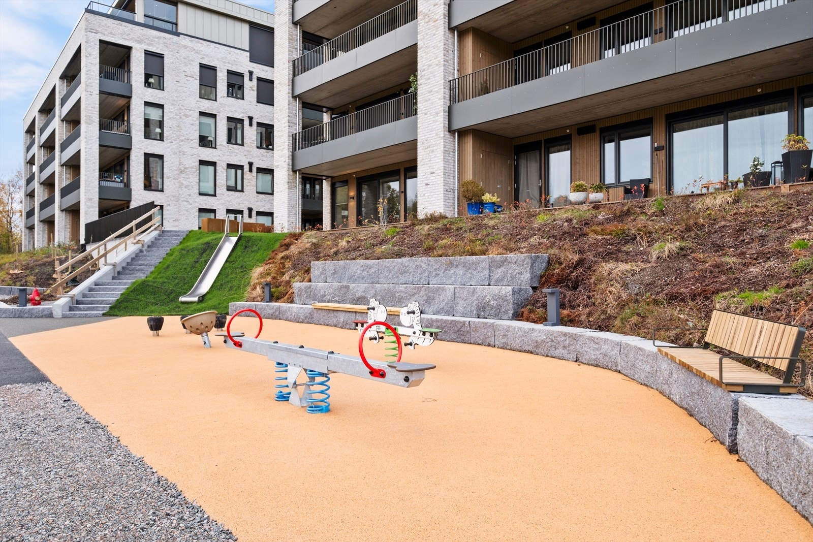 Felles lekeplass med støpt dekke og lekeutstyr gir et trygt og sosialt uteområde. Galleribilde