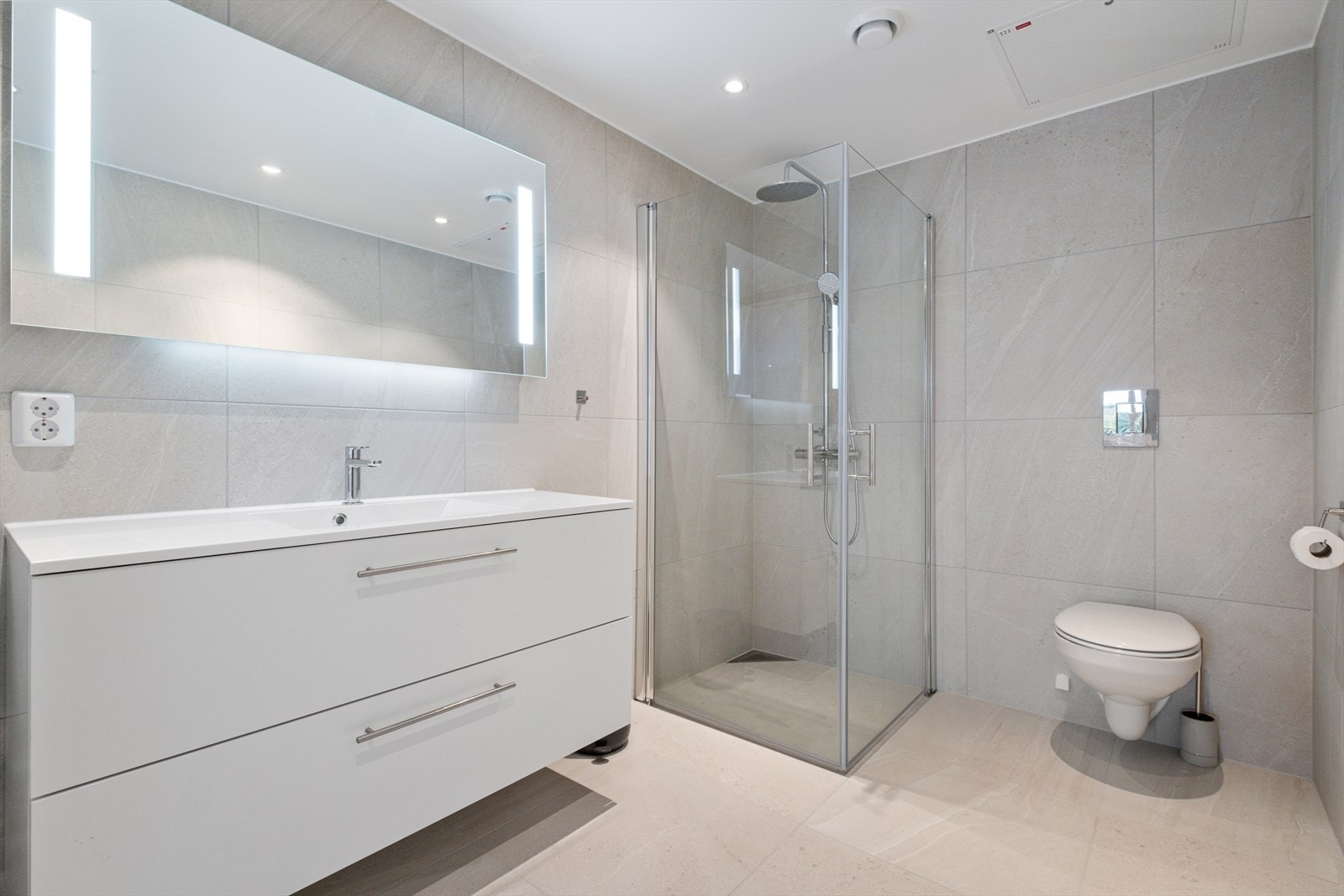 Lyst helfliset bad med elektriske varmekabler på gulv. Galleribilde