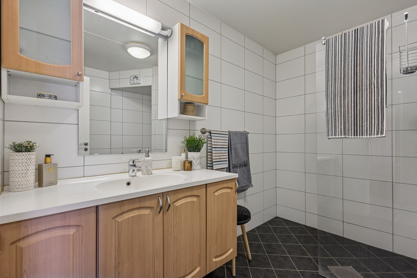 Badet er helfliset på gulv og vegger, og har varme i gulvet for ekstra komfort. Galleribilde