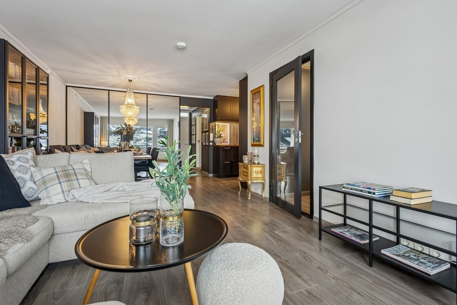 En dør med glassfelt og sorte sprosser skiller elegant av mot det ene soverommet. Galleribilde