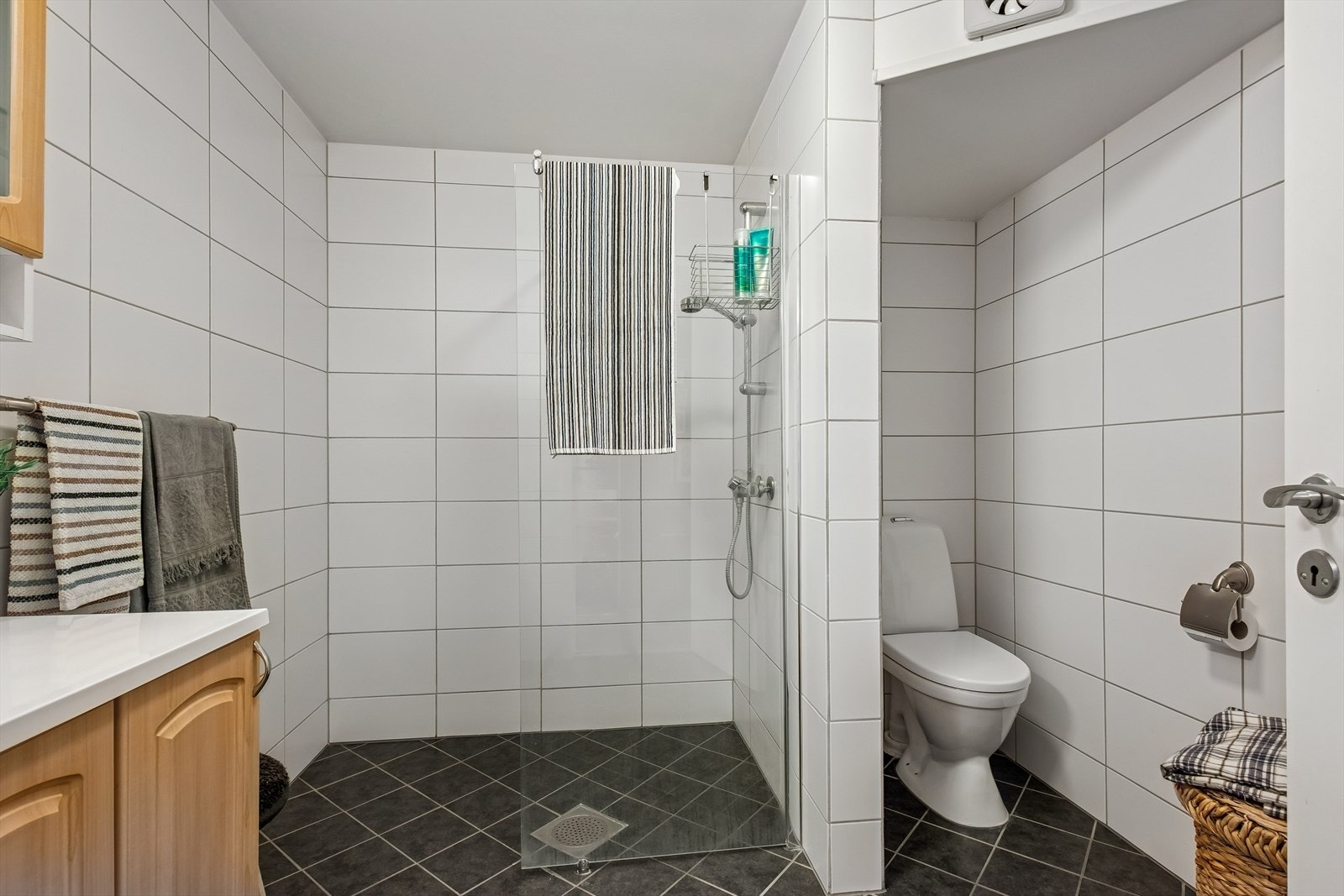 Rommet er utstyrt med dusjvegger i glass og et gulvmontert toalett. Galleribilde