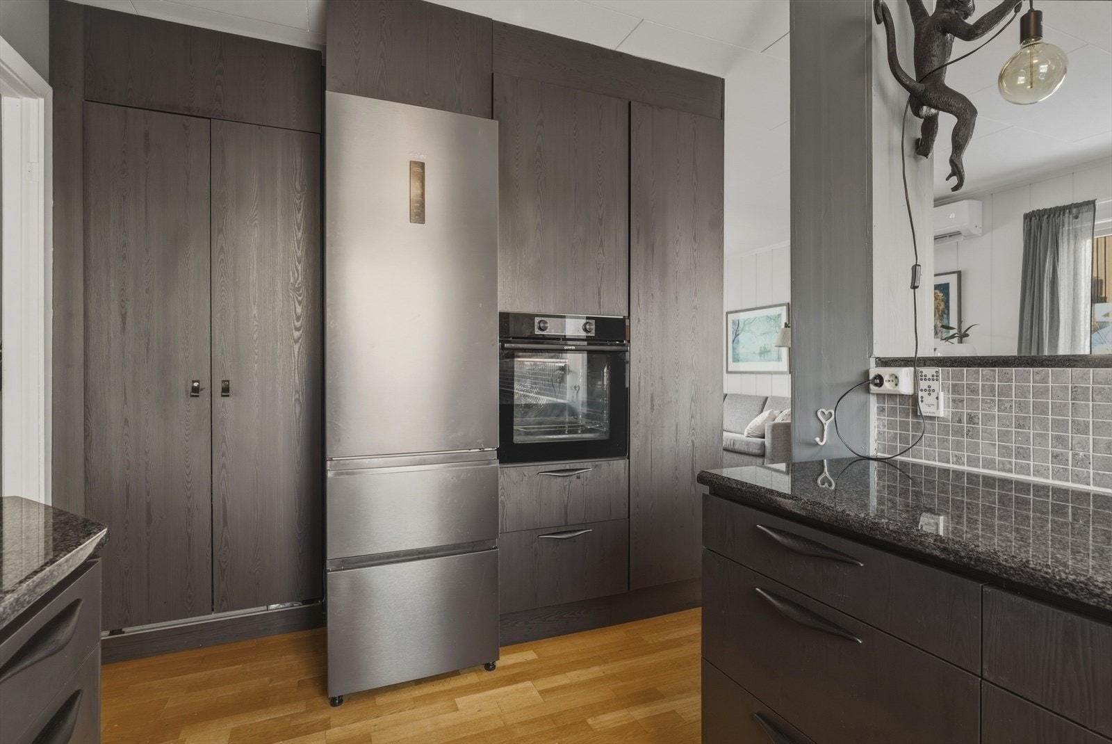 Boligen har et stilfullt kjøkken i mørk trefinér med benkeplate av stein. Kjøkkeninnredningen ble oppusset/fornyet før julen 2024, og avbildet innredning ble da tilført for ytterligere oppbevaringsplass. Galleribilde