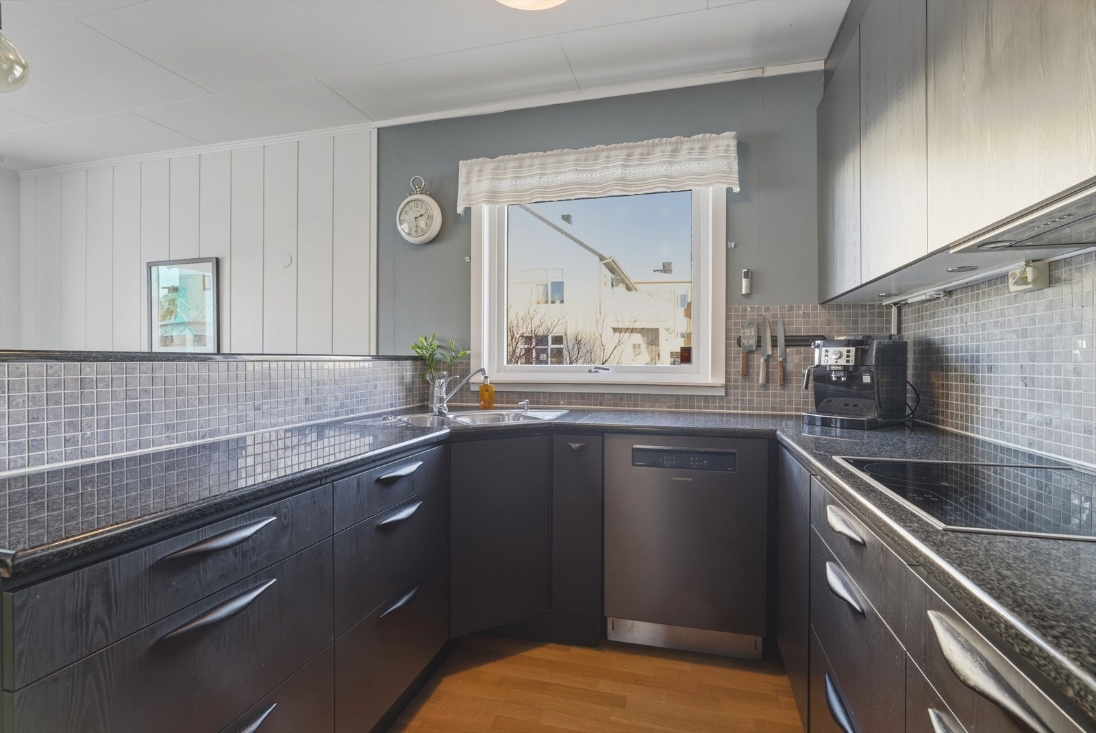 Halvveggen mot spisestuen gjør kjøkkenet sosialt, samtidig som det skjermer innsyn til arbeidsflaten. Galleribilde