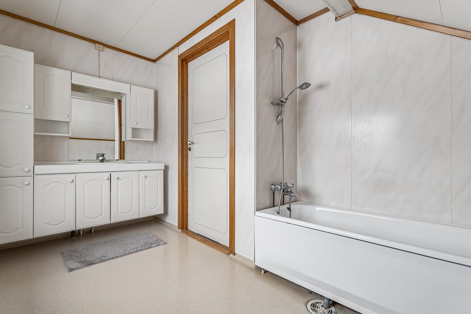 Badet er innredet med badekar med dusj og servantskap med god oppbevaringsplass. Galleribilde