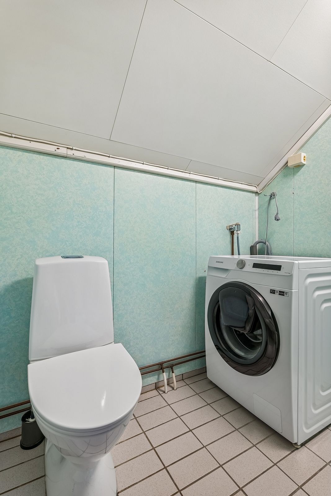 Boligen har et separat vaskerom med flislagt gulv, toalett og opplegg for vaskemaskin. Galleribilde