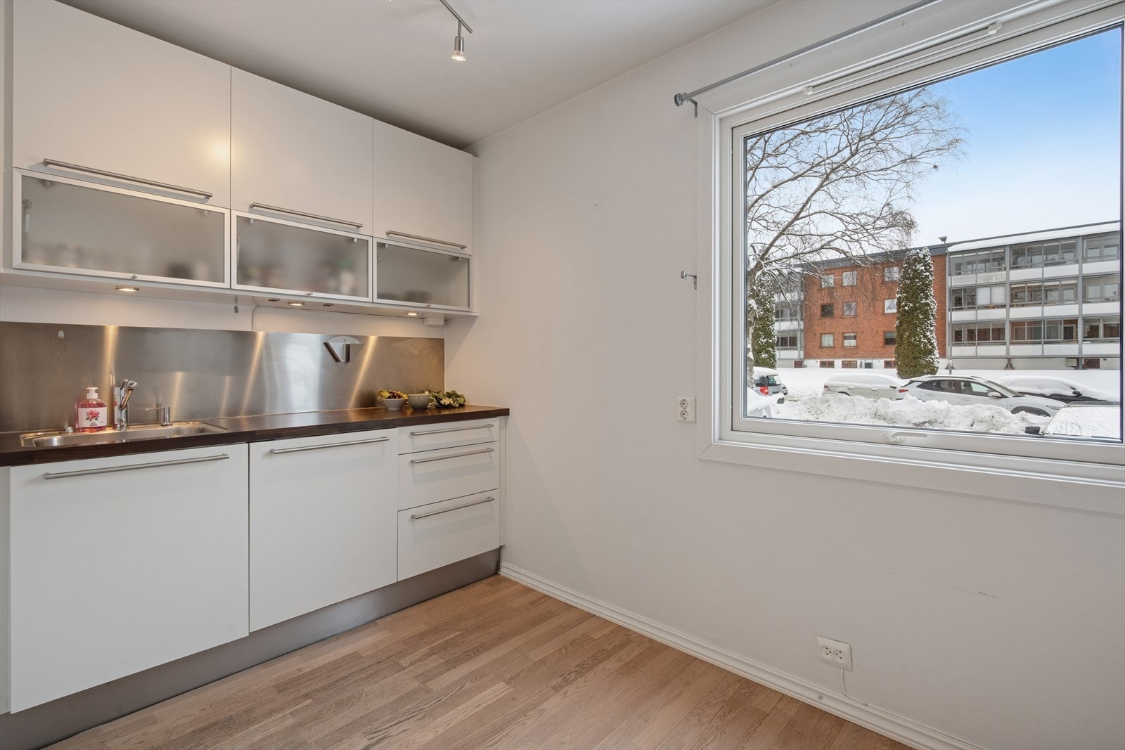 Det er stikkontakt på vegg over benk, stålplate mellom benk og overskap samt belysning under overskapene. Galleribilde