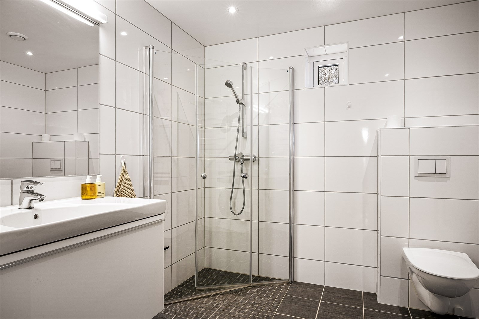 Lekkert bad på 5,5 m² i et tidløst design og spotlight i taket. Galleribilde