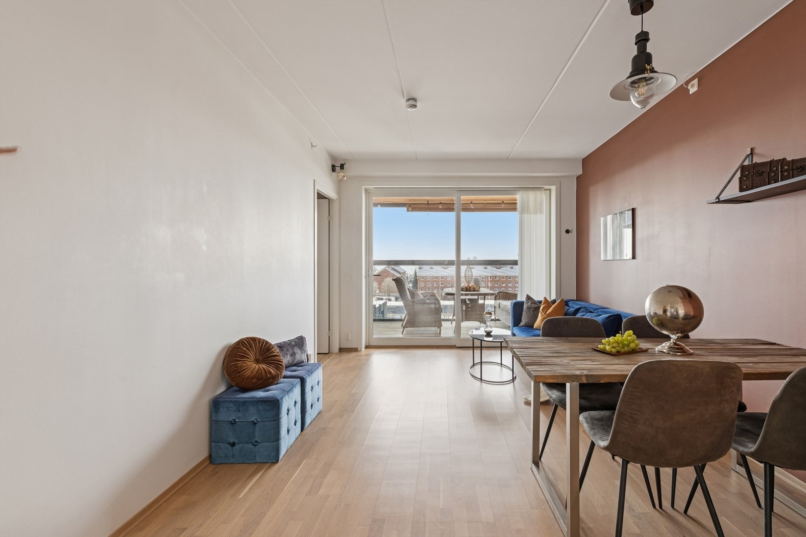 Store skyvedører i glass åpner opp mot balkongen og slipper inn rikelig med naturlig lys i oppholdsrommet. Galleribilde