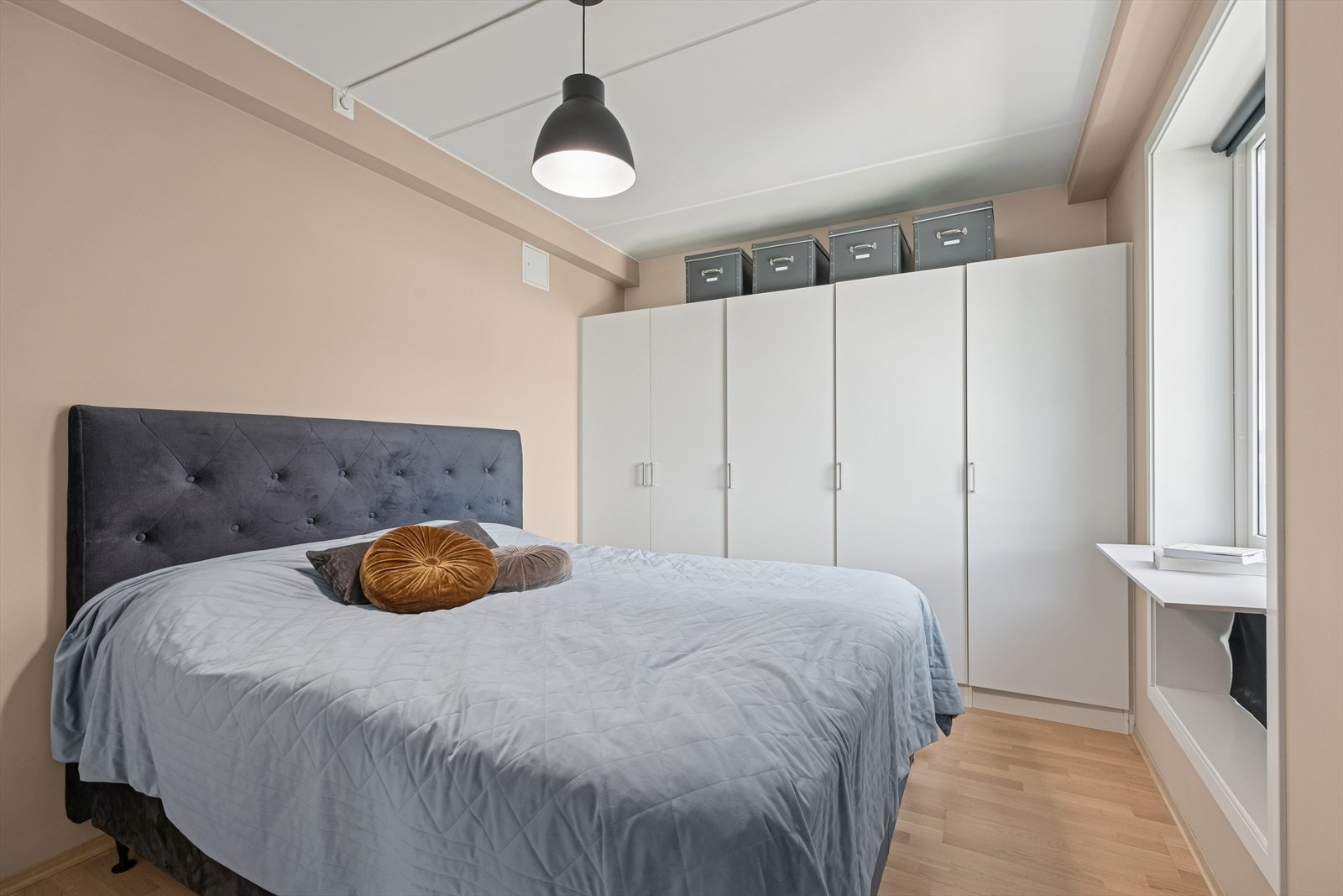 Garderobeskap med glatte fronter gir effektiv oppbevaring i rommet. Galleribilde