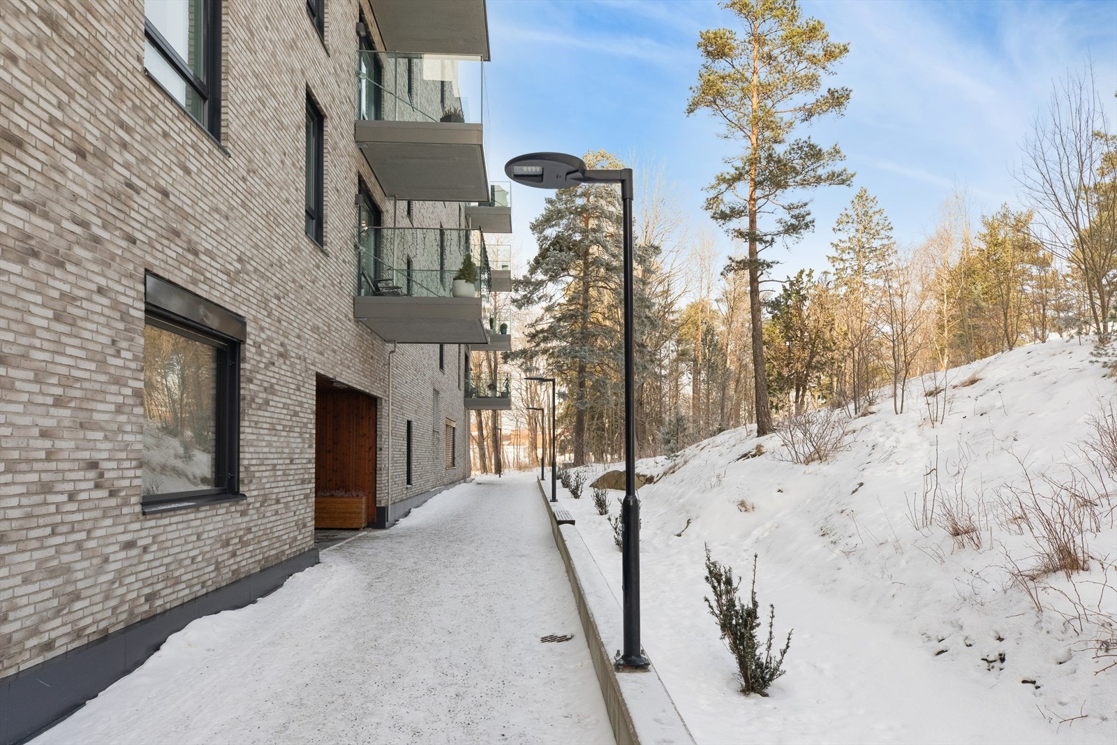 Tomten er parkmessig opparbeidet med asfalterte internveier, steinsatte arealer, blomsterbed, variert beplantning, lekeapparater og sittegrupper. Galleribilde