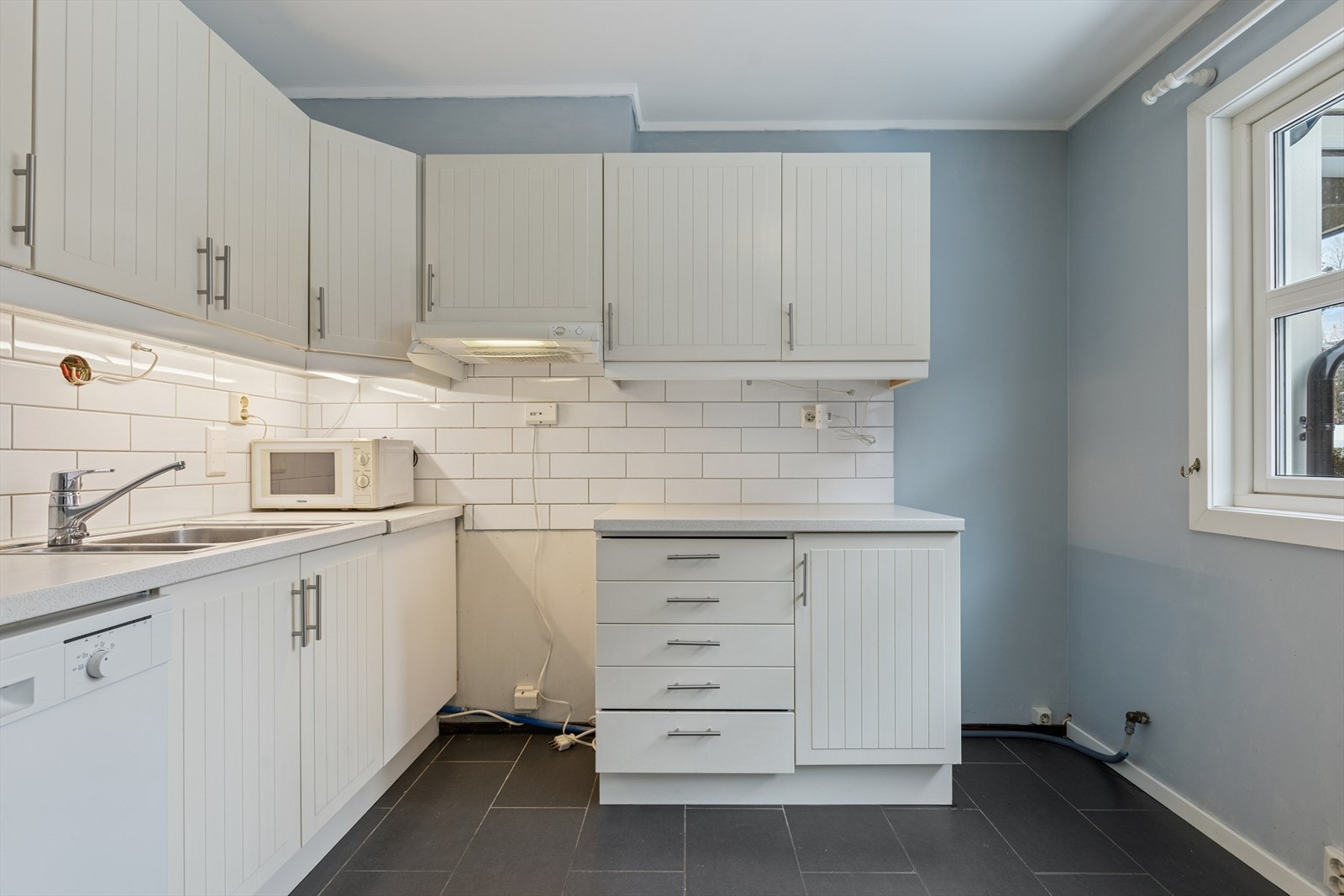 Kjøkkeninnredningen gir rikelig med skap- og benkeplass. Galleribilde