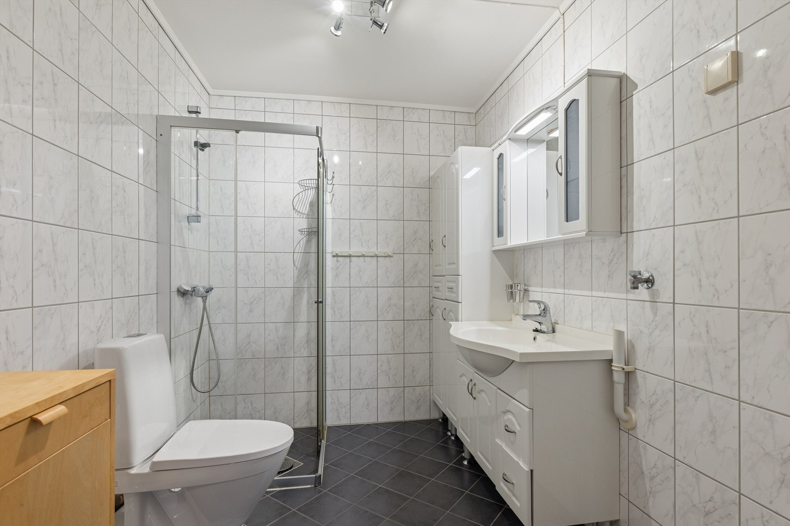 Flislagt bad med dusjhjørne, servantinnredning og WC som ble skiftet i 2022. Galleribilde