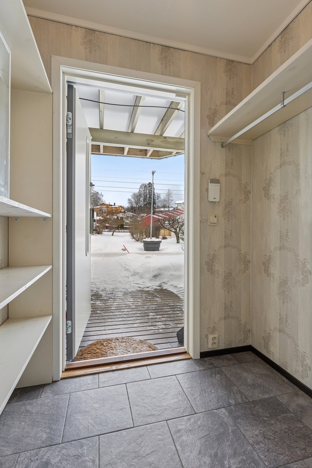 Entréen har flislagt gulv og gir direkte tilgang til en romslig uteplass på 15 m² ved inngangen. Galleribilde