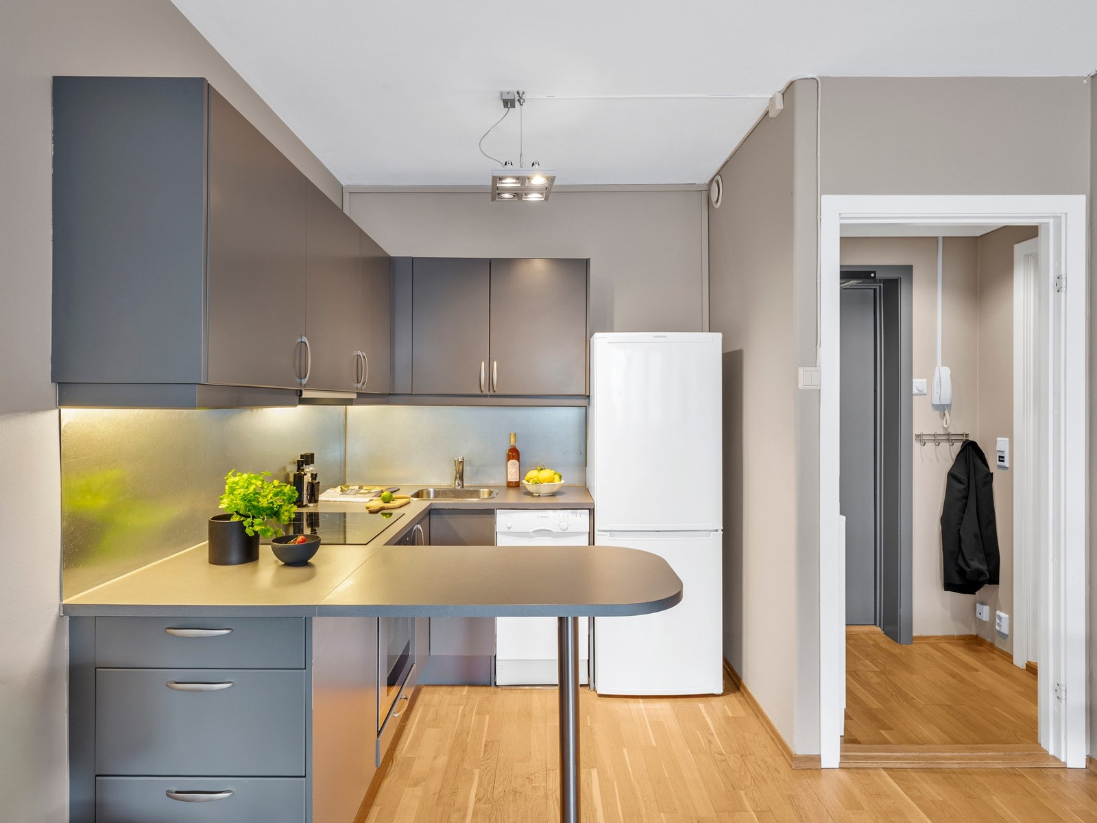 Kjøkkenet har en åpen og sosial løsning. Kombinasjonen av god skap-/og benkeplass bidrar til en ryddig og praktisk arbeidsflate Galleribilde