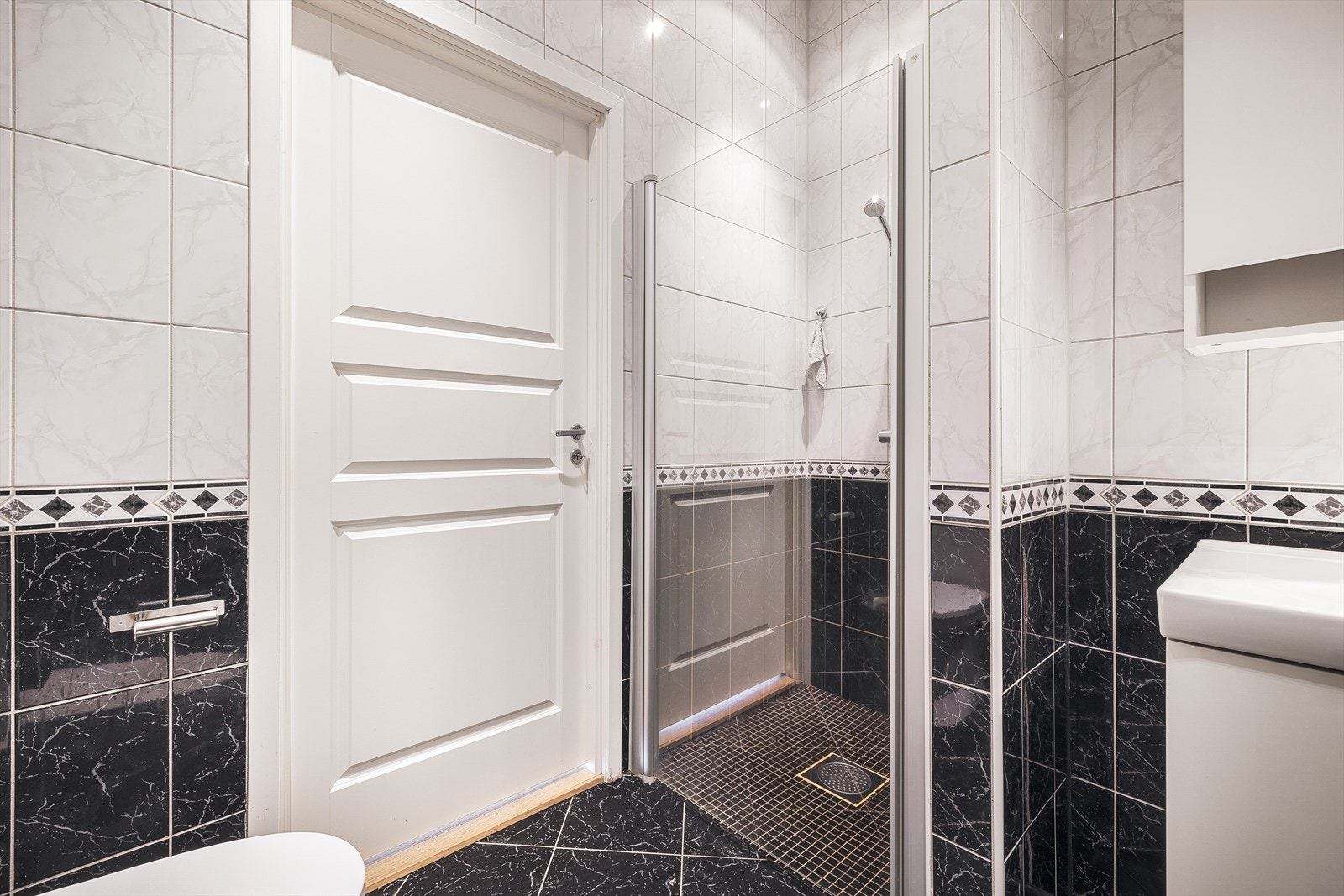 Badet inneholder kvaliteter som underletter for hverdagslige gjøremål, derav toalett, dusjhjørnet med dusjgarnityr, baderomsmøblement med servant og skap/skuffeplass. Galleribilde