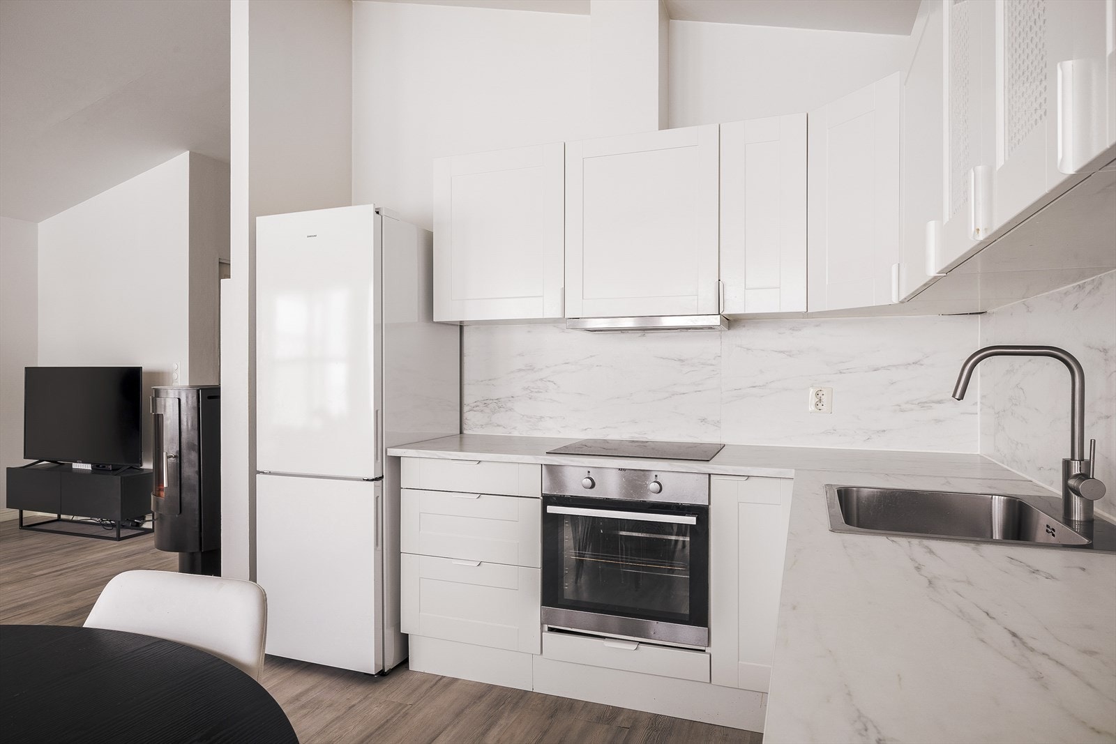 Over benkeplaten er det keramiske fliser med lekkert marmormønster som fremmer et moderne uttrykk. Galleribilde