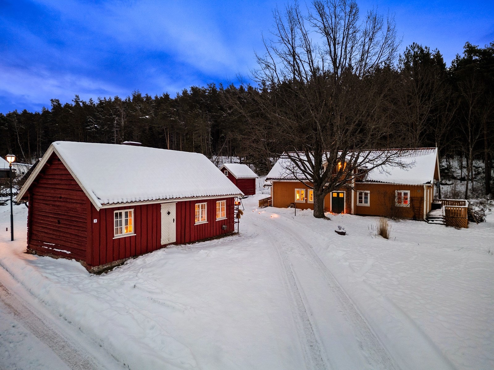 Et koselig tun med flere bygninger slik som Rødstua, stabbur og garasje/uthus Galleribilde