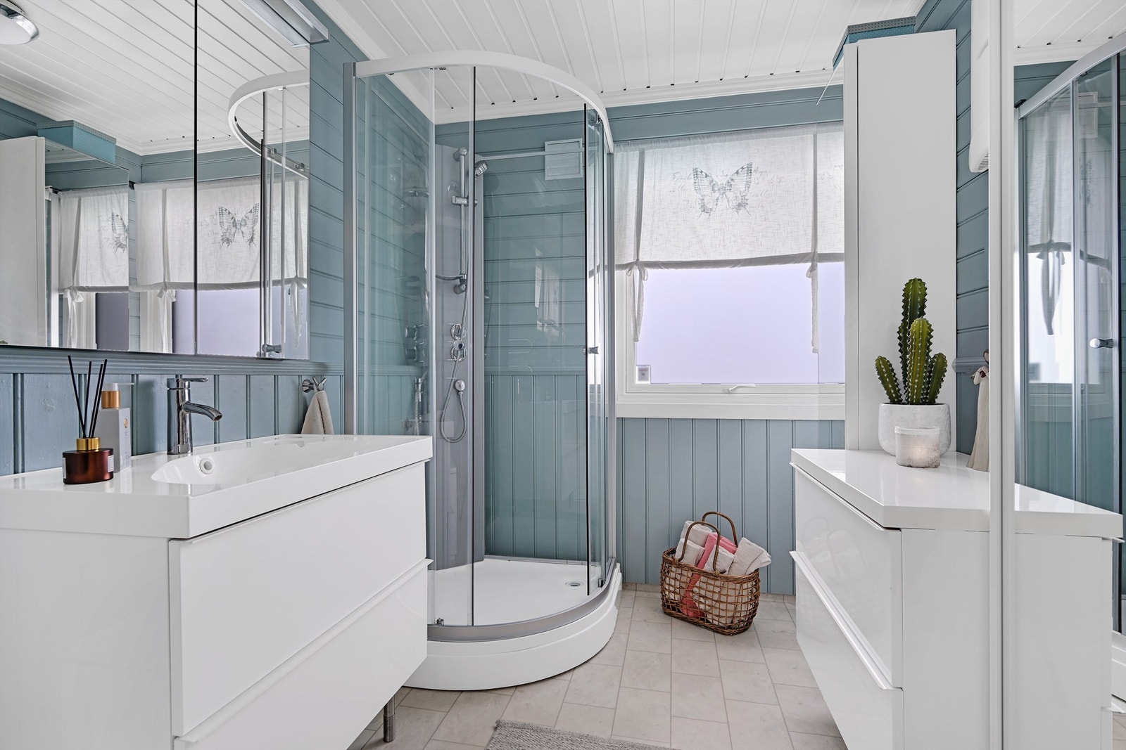 Badet er innredet med gulvmontert toalett, badekar, baderomsinnredning med nedfelt vask og dusjkabinett. Galleribilde