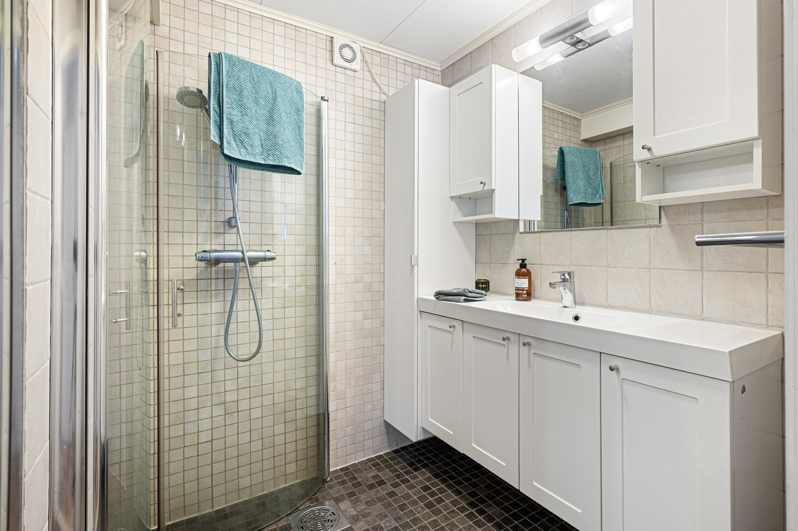 Lyst flislagt bad med alt man trenger. Galleribilde