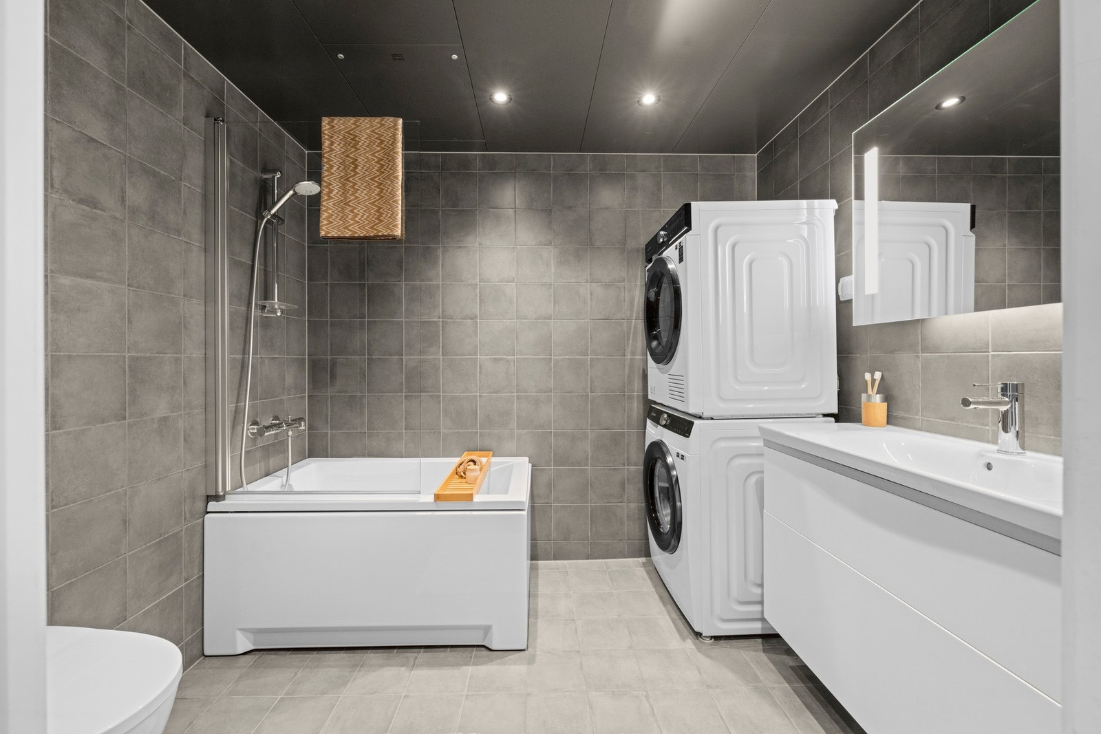 I tilknytning til gangen, boden og soverom 2 & 3 finner du hjemmets hoved-bad med badekar og opplegg for vask og tørk. Galleribilde